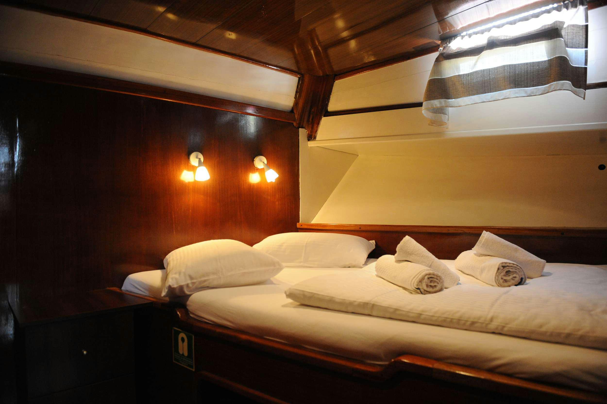 a room with a bed and a window aboard AGORA Yacht for Charter