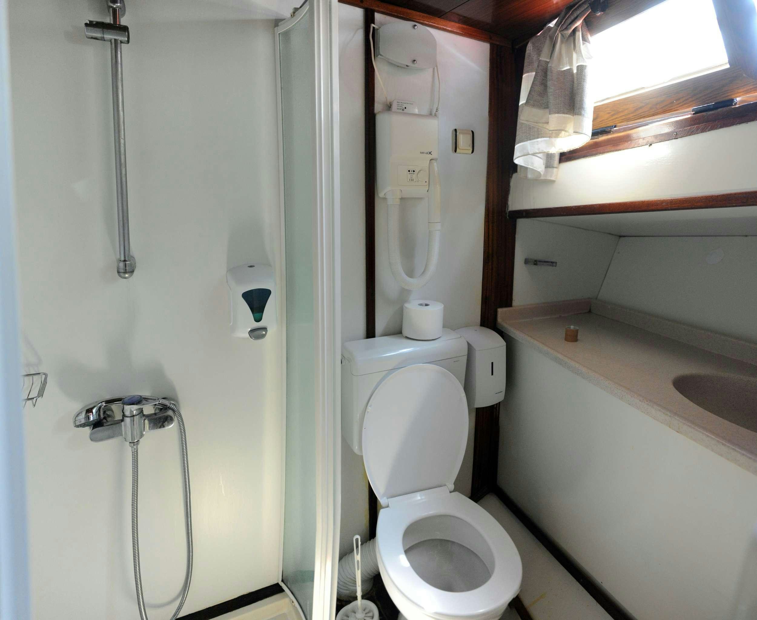 a bathroom with a toilet and sink aboard AGORA Yacht for Charter
