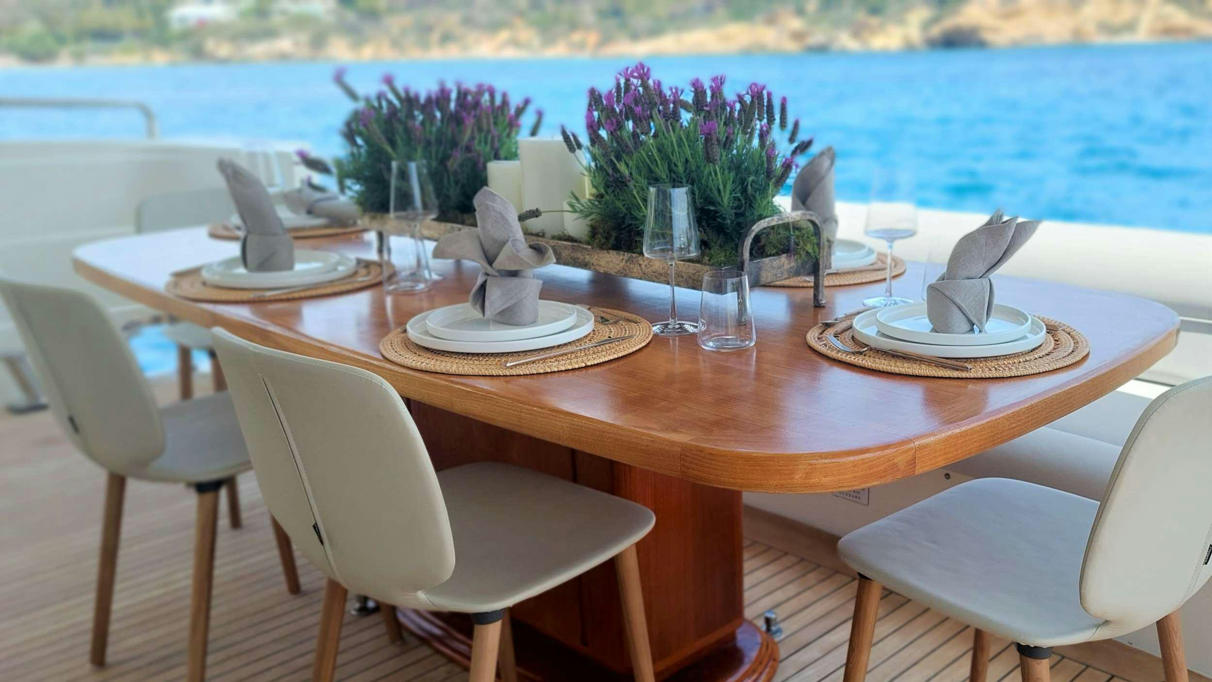 a table with chairs and vases on it aboard VA BENE Yacht for Charter