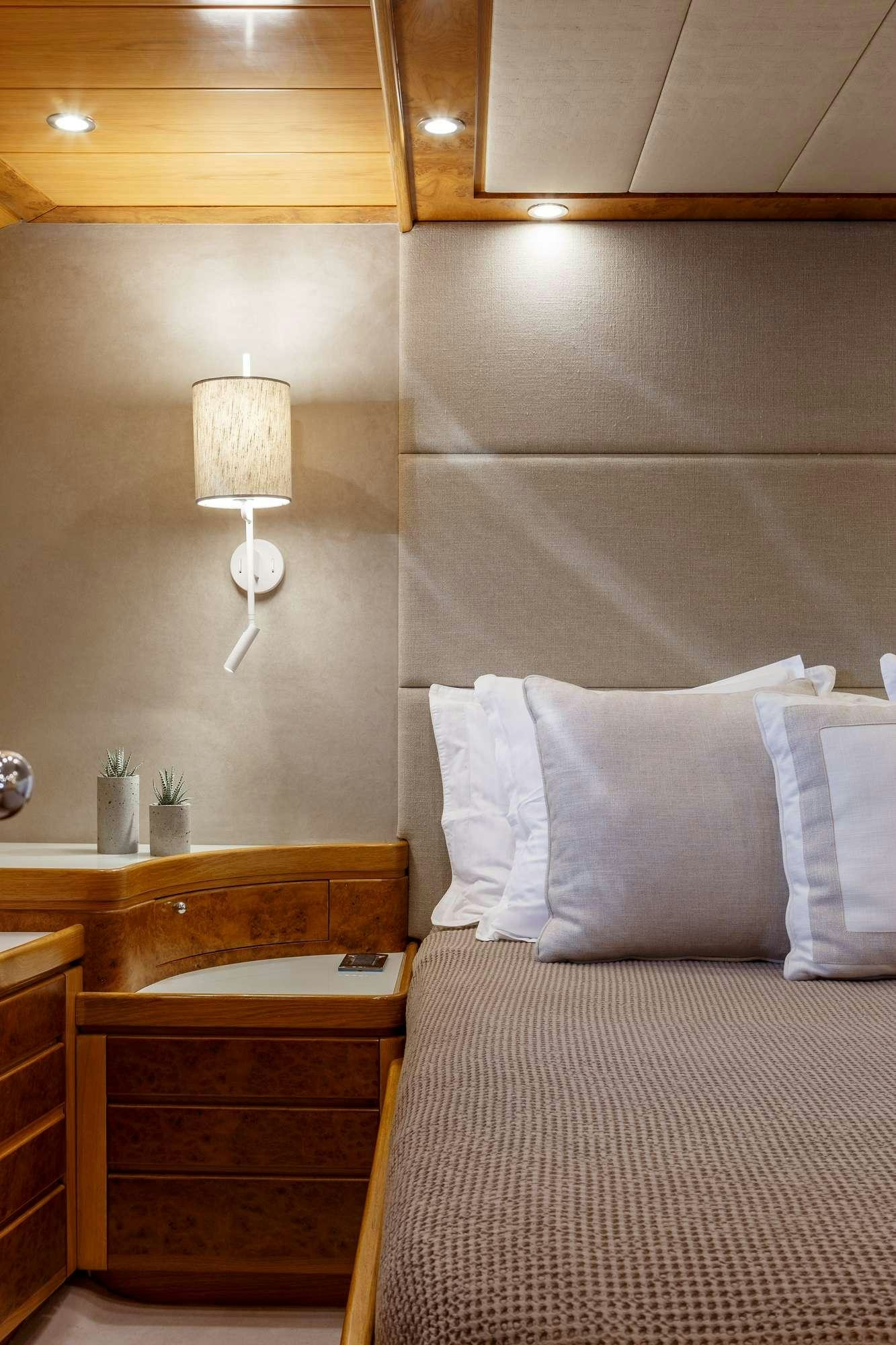 a bedroom with a bed and a lamp aboard VA BENE Yacht for Charter