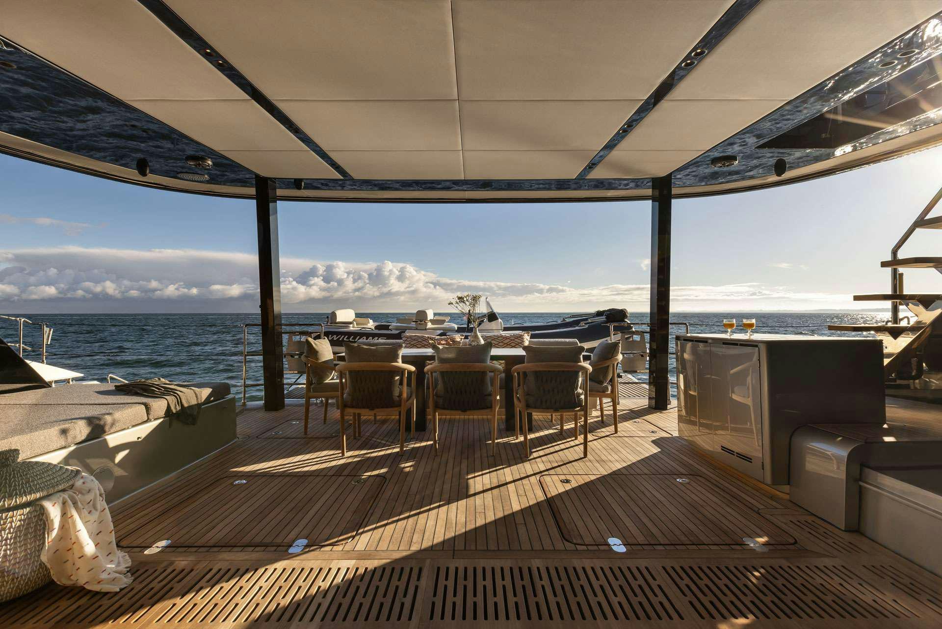 a deck with tables and chairs on it aboard OTOCTONE Yacht for Charter