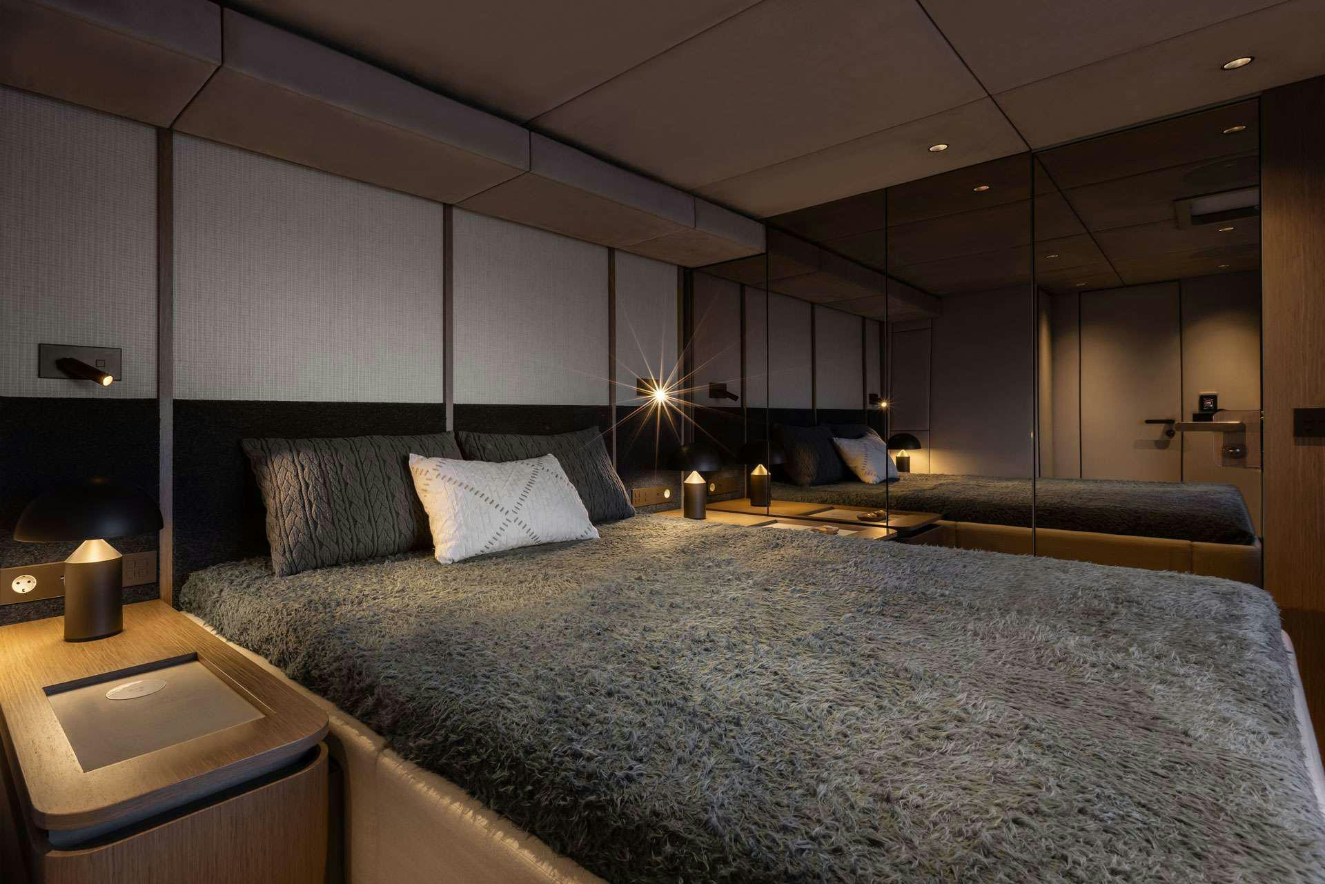 a bed with a blue comforter aboard OTOCTONE Yacht for Charter