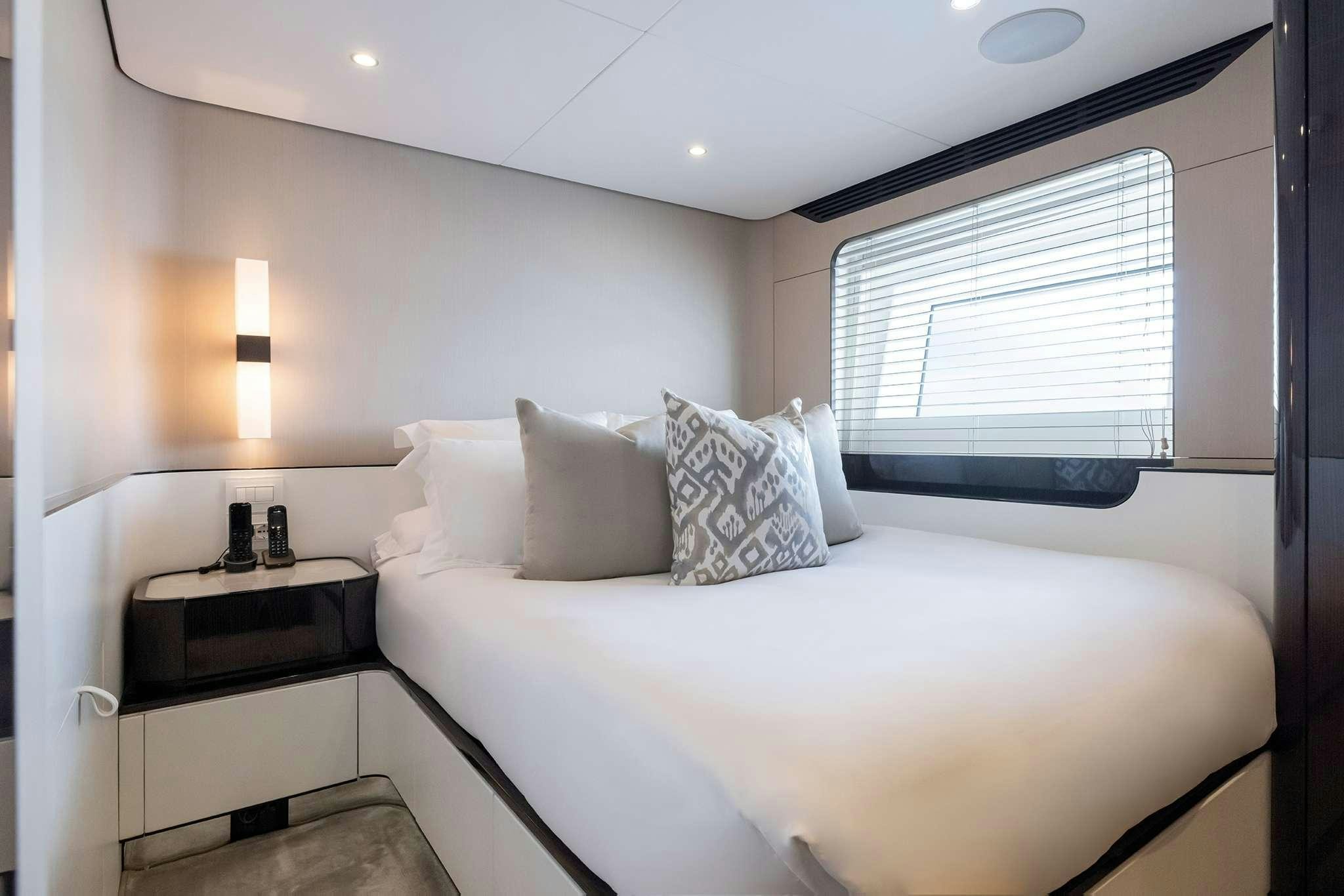 a bed with a white sheet and a white pillow aboard NEMESIS Yacht for Charter