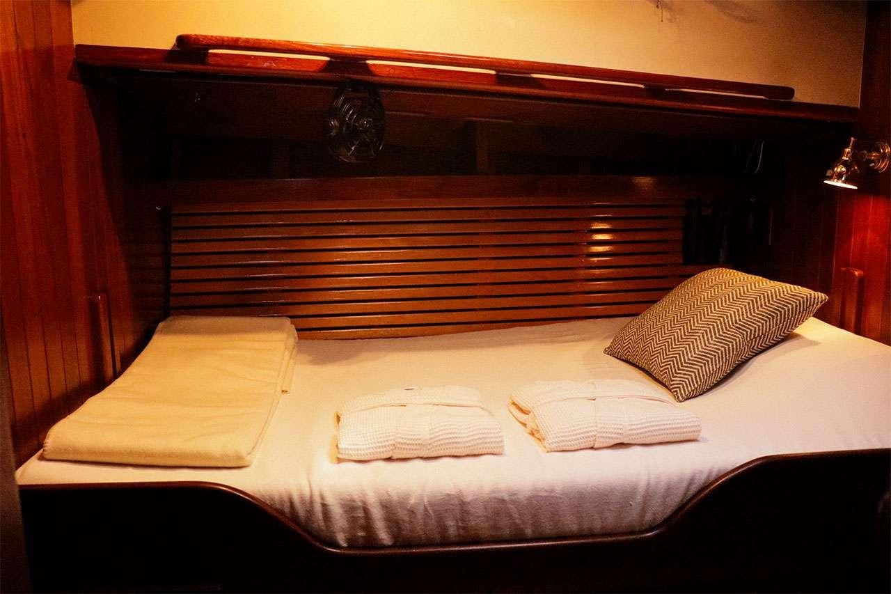 a bed with white sheets aboard TREE OF LIFE Yacht for Charter