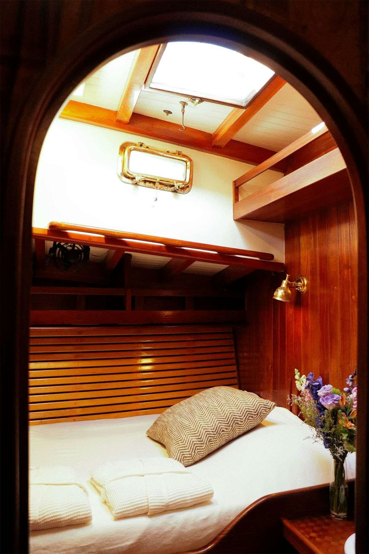 a bed with a white bed spread aboard TREE OF LIFE Yacht for Charter