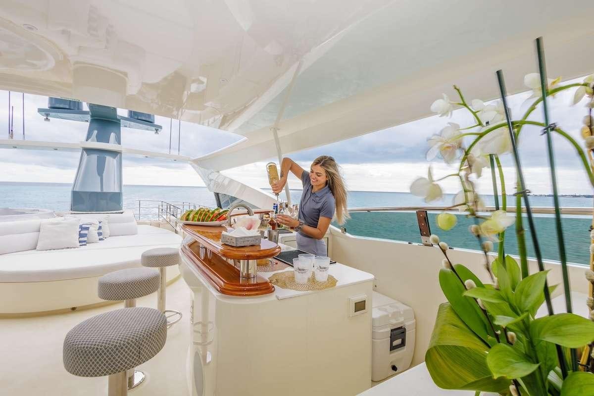 a person standing next to a table aboard BLACKSHEEP Yacht for Charter
