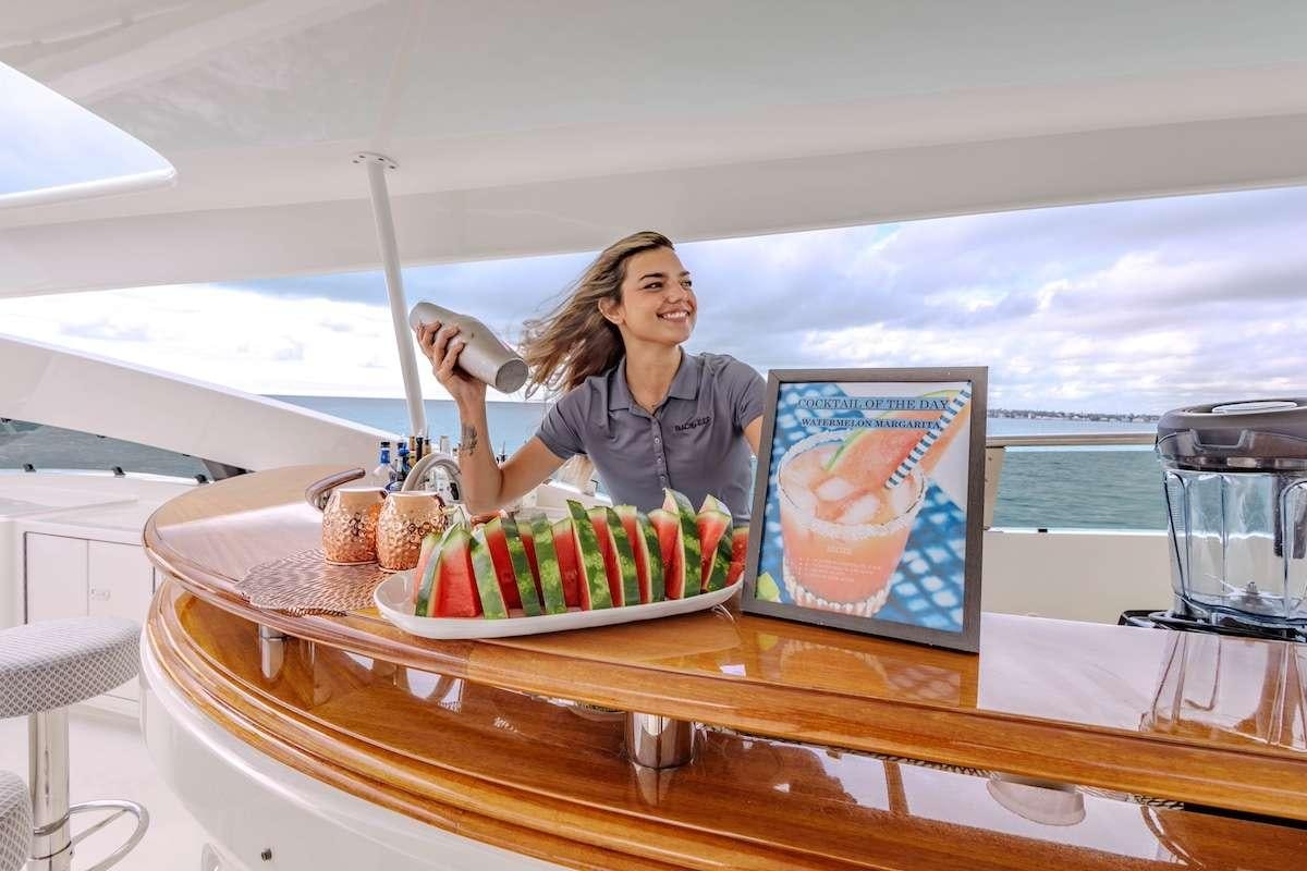 a person sitting at a table with a plate of food and a laptop aboard BLACKSHEEP Yacht for Charter