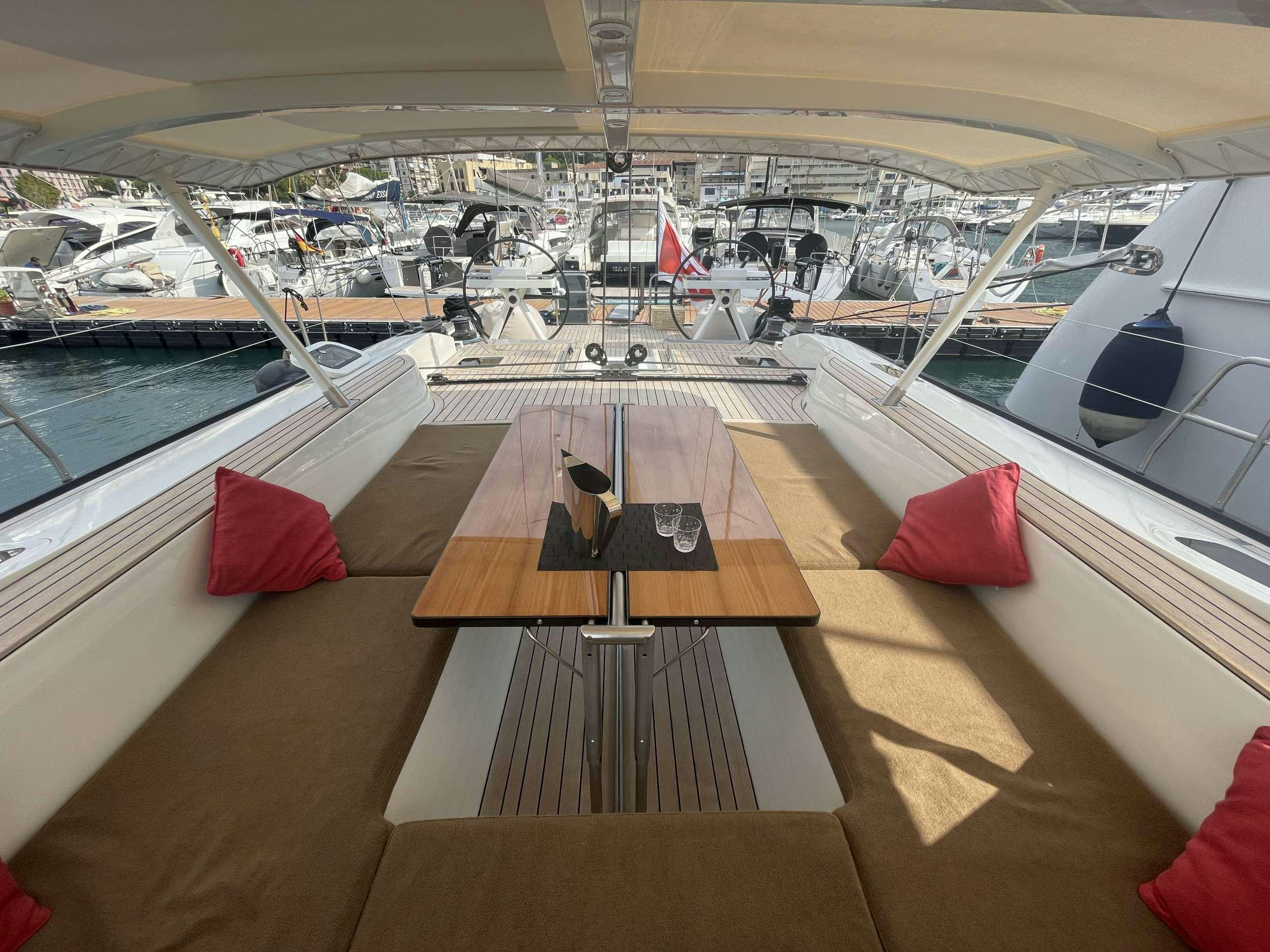 a cat sitting on a bench on a deck overlooking a marina aboard BLACK PEARL II Yacht for Charter
