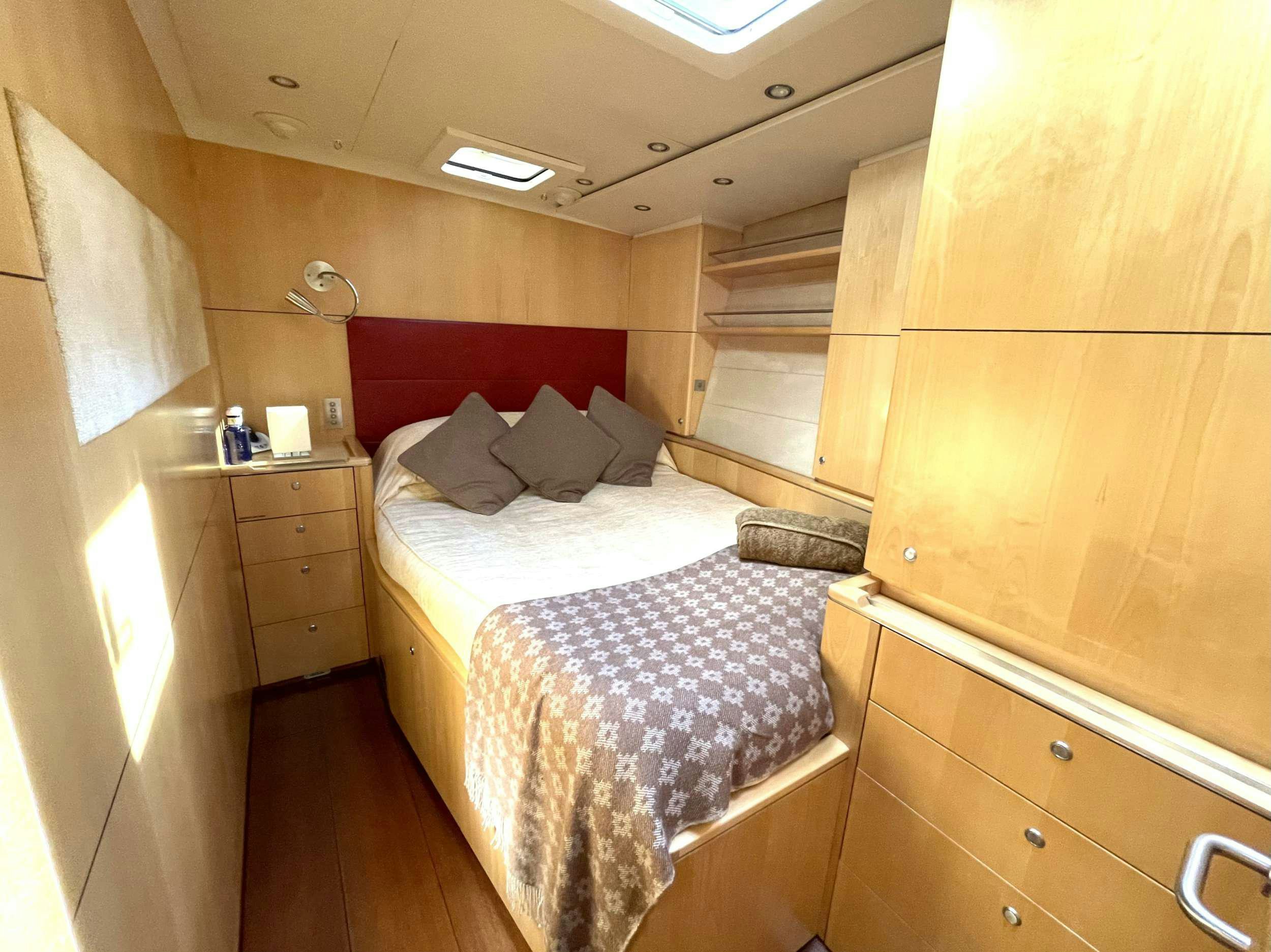 a room with a bed and a dresser aboard BLACK PEARL II Yacht for Charter