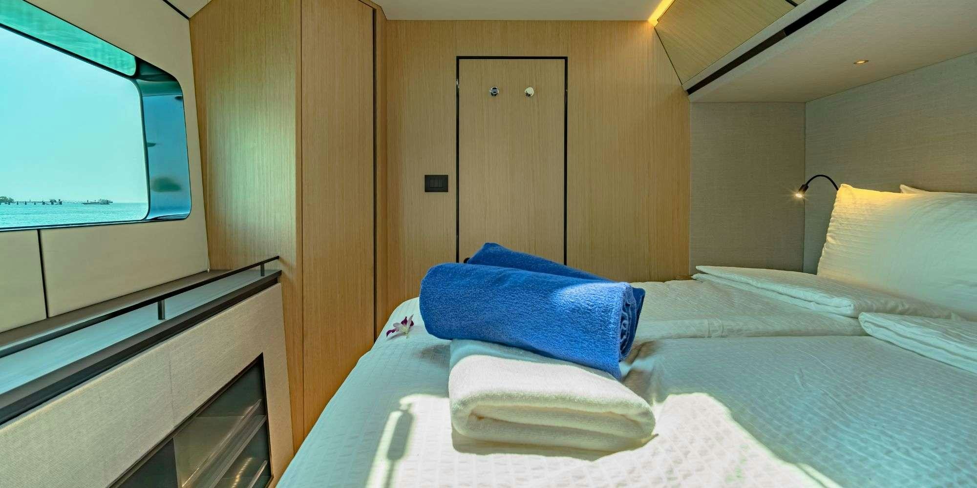 a bed with a blue pillow aboard JACK Yacht for Charter