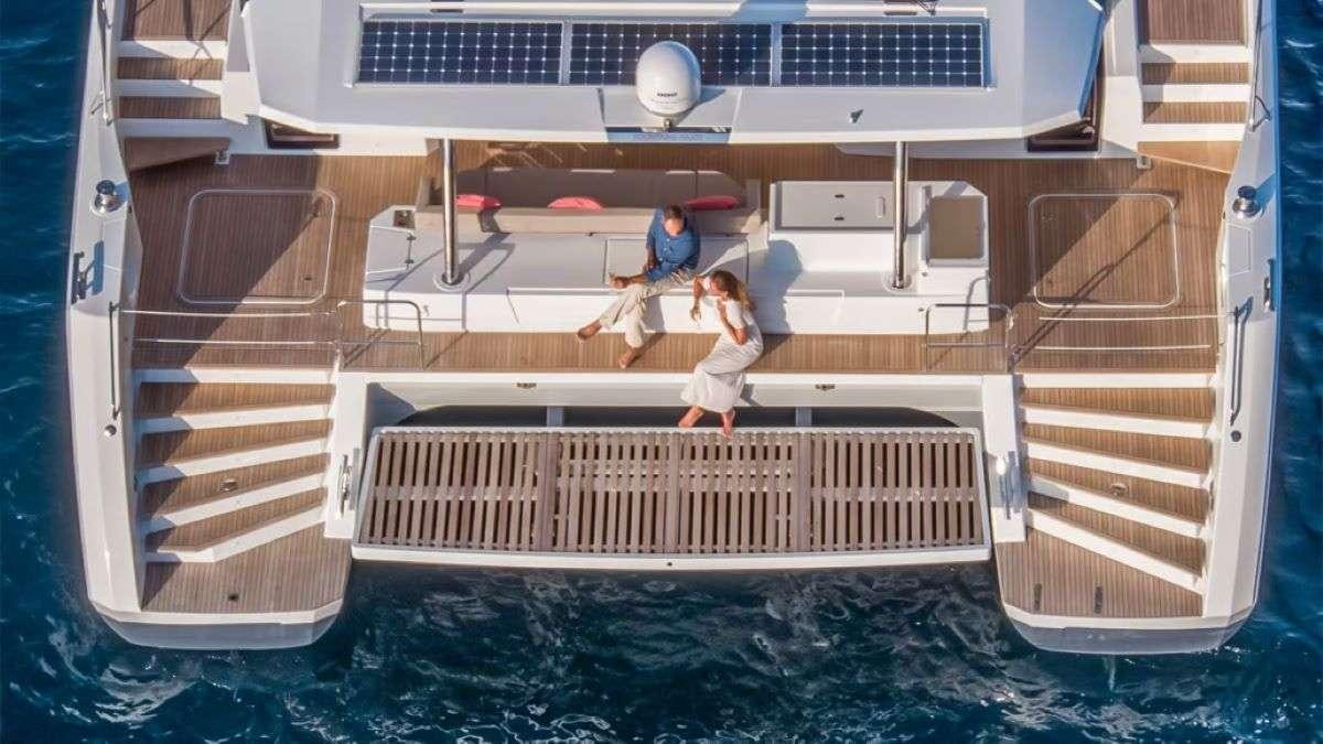 a man and a woman walking on a dock aboard THE BLUE DREAM Yacht for Charter