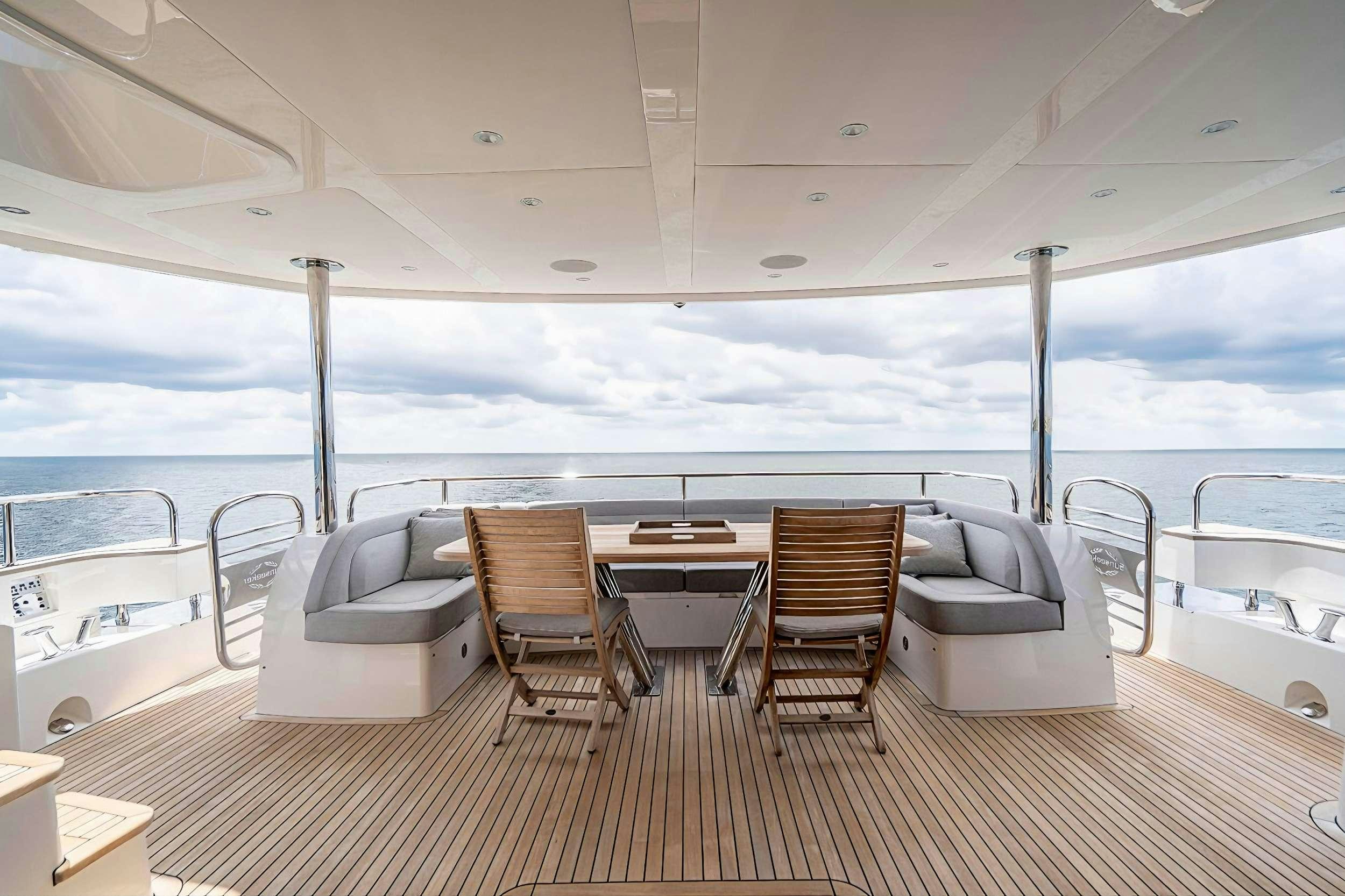 a large white boat with a table and chairs on a deck aboard QUANTUM Yacht for Charter