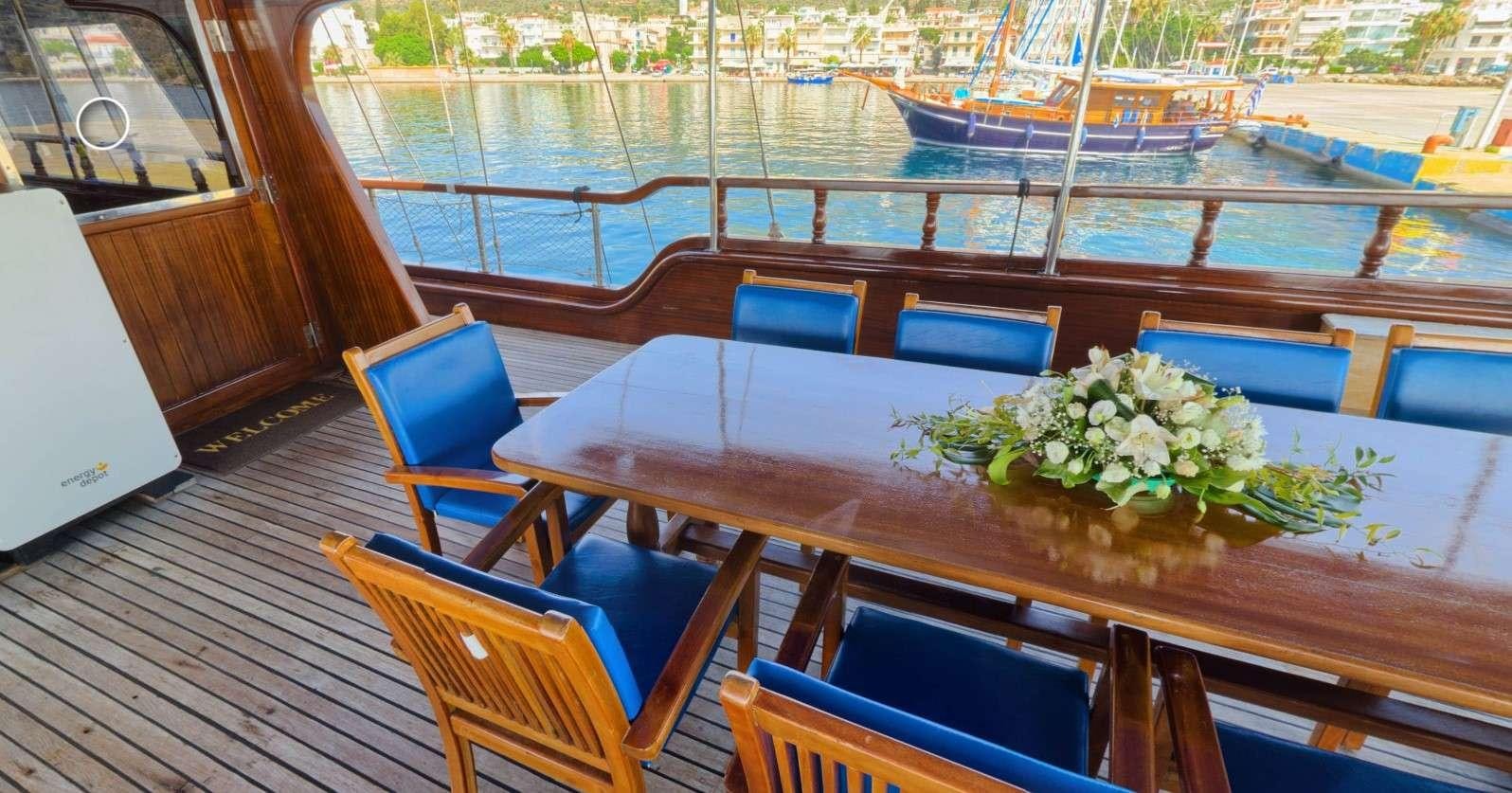 a table with chairs and flowers on it aboard THALASSA Yacht for Charter