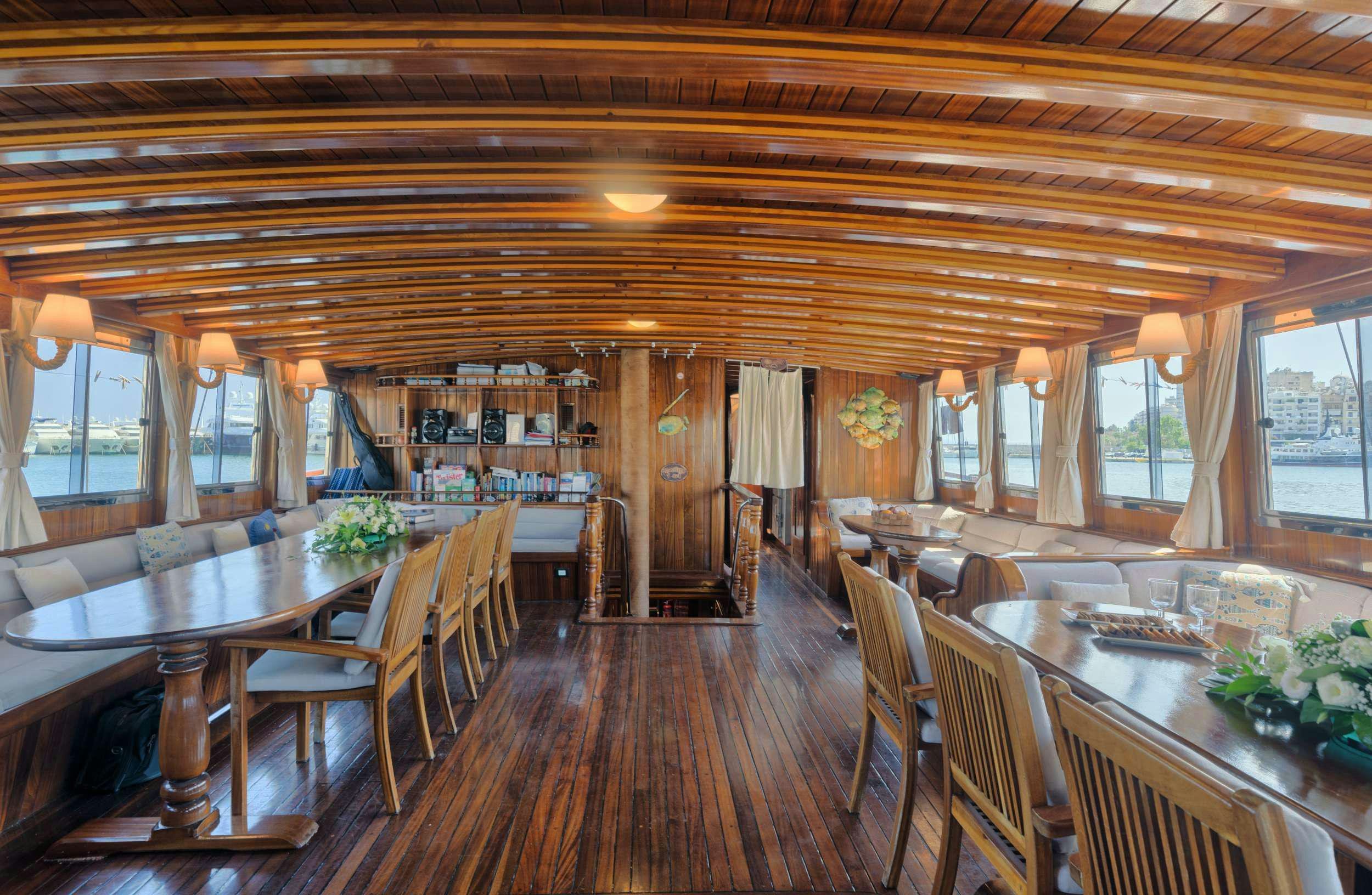 a large room with tables and chairs aboard THALASSA Yacht for Charter