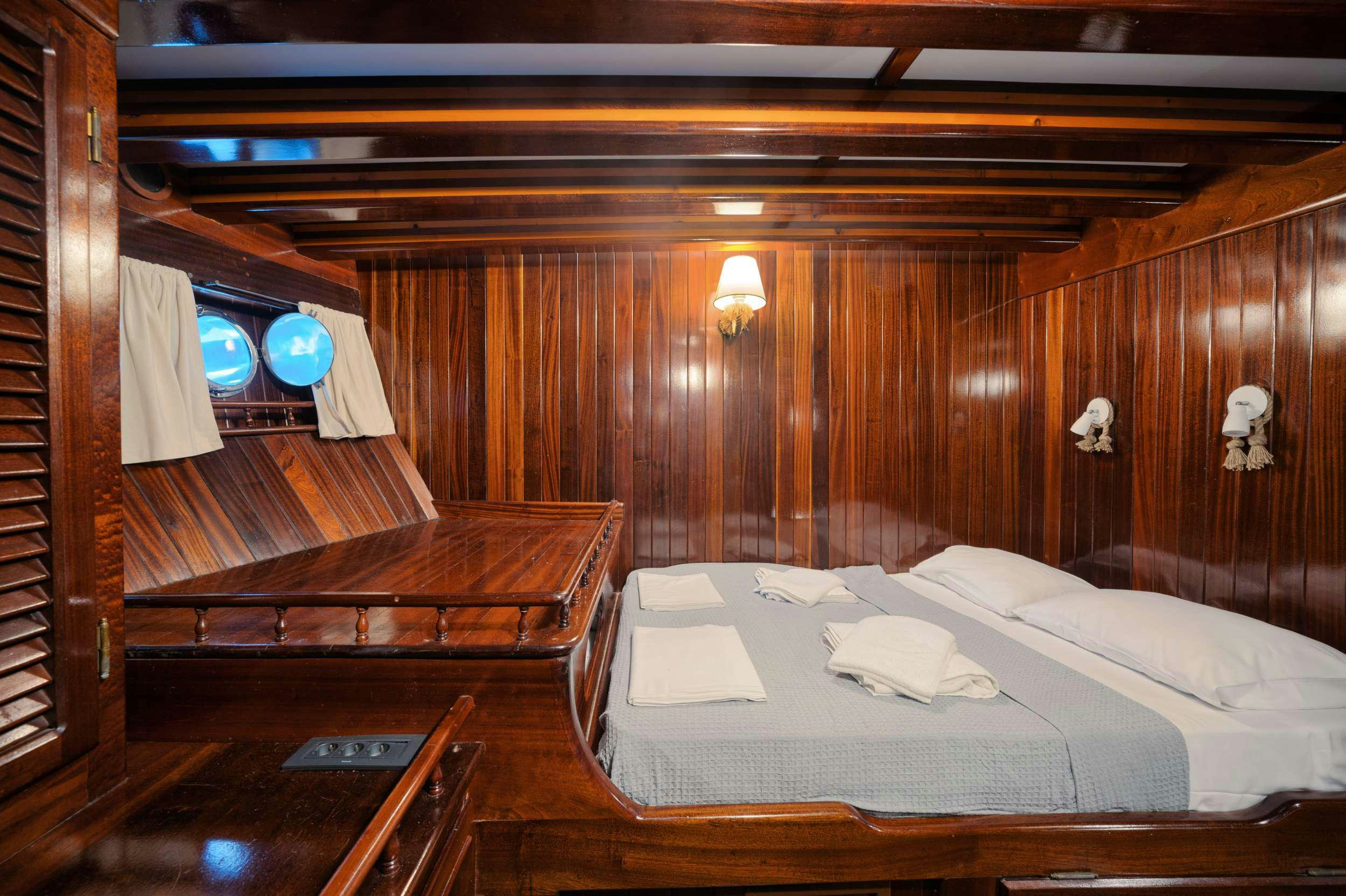 a room with a bed and a desk aboard THALASSA Yacht for Charter
