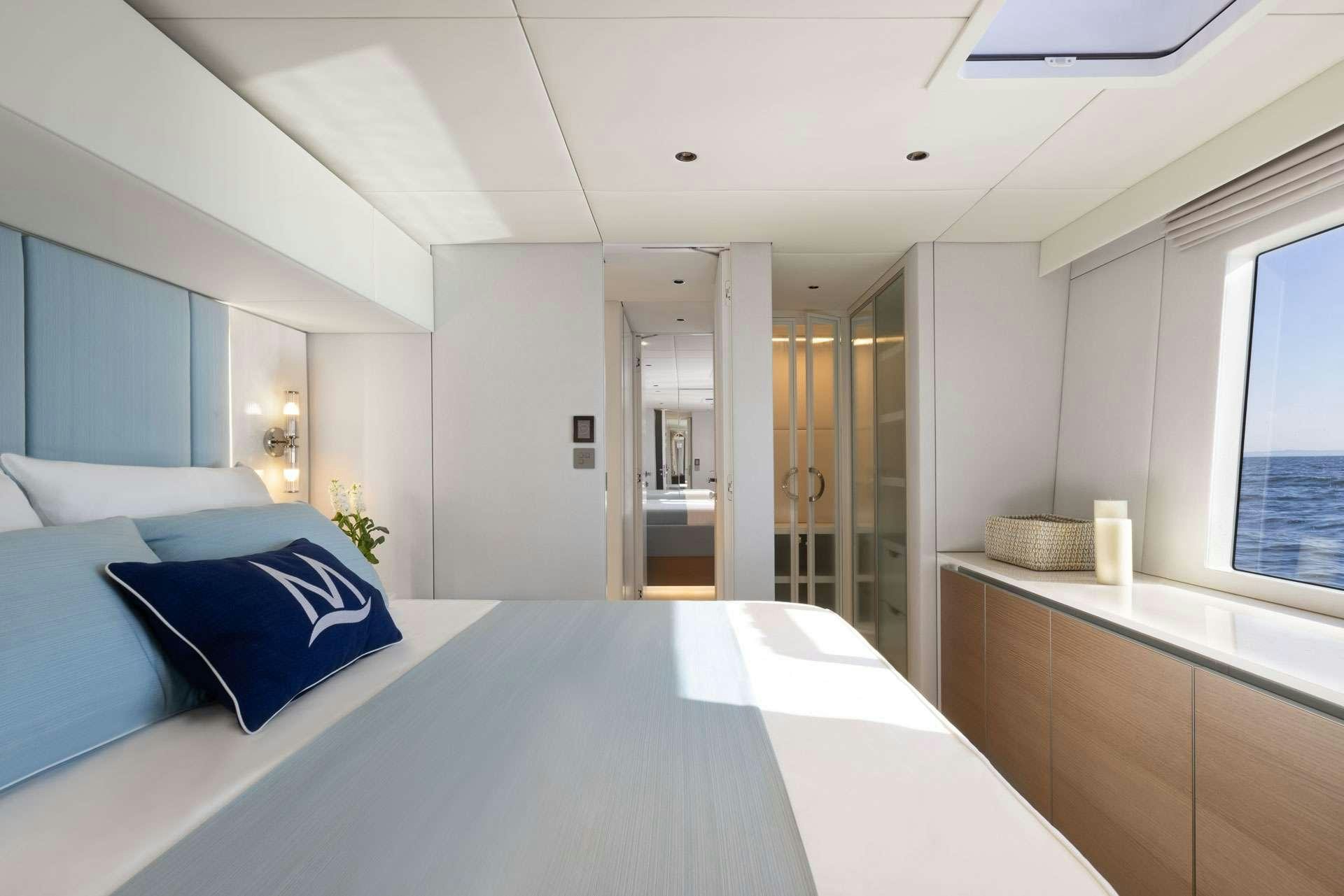 a large white room with a large white table and blue pillows aboard MISCHIEVOUS Yacht for Charter