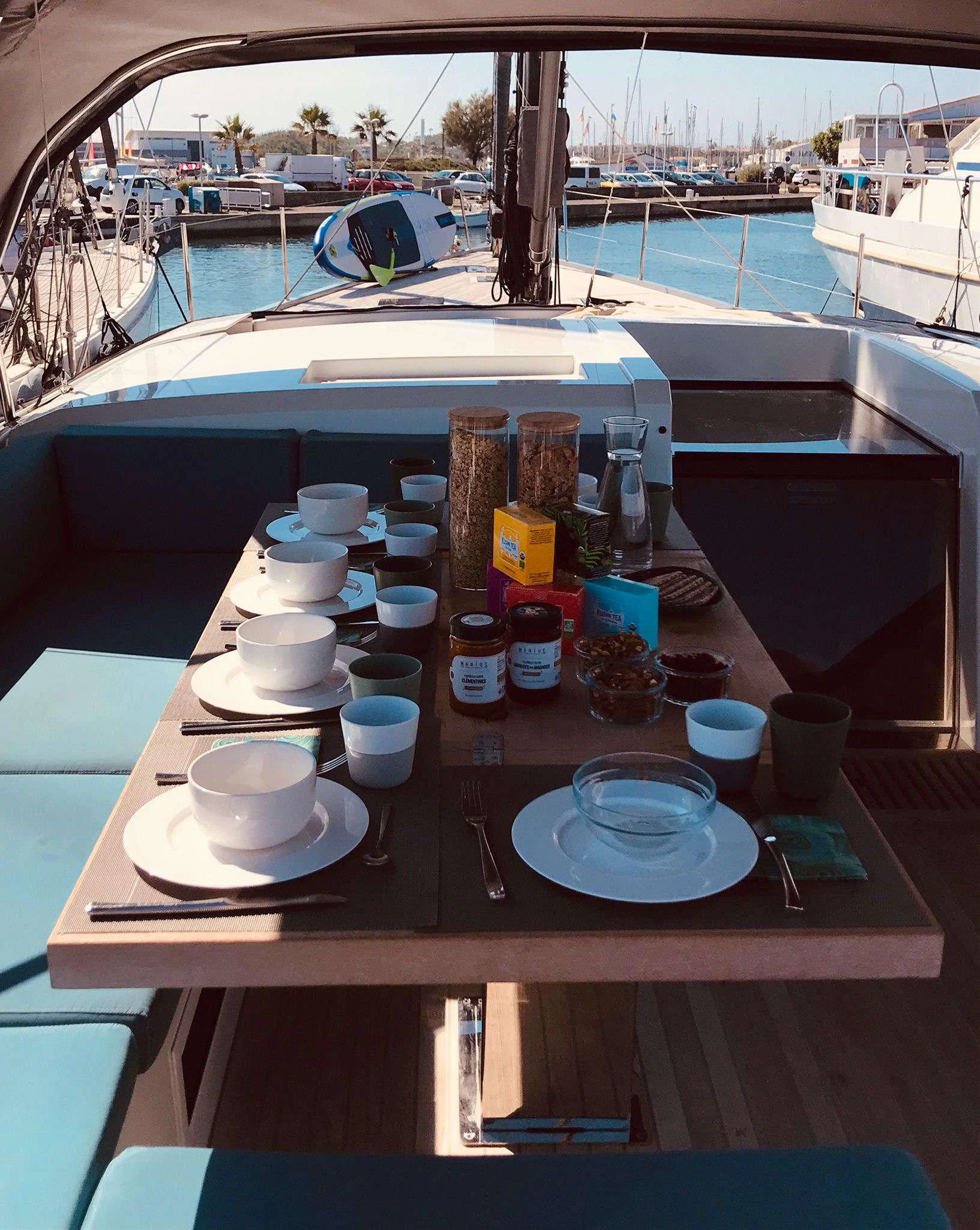 a table with plates and cups on it aboard MAHINA 3 Yacht for Charter