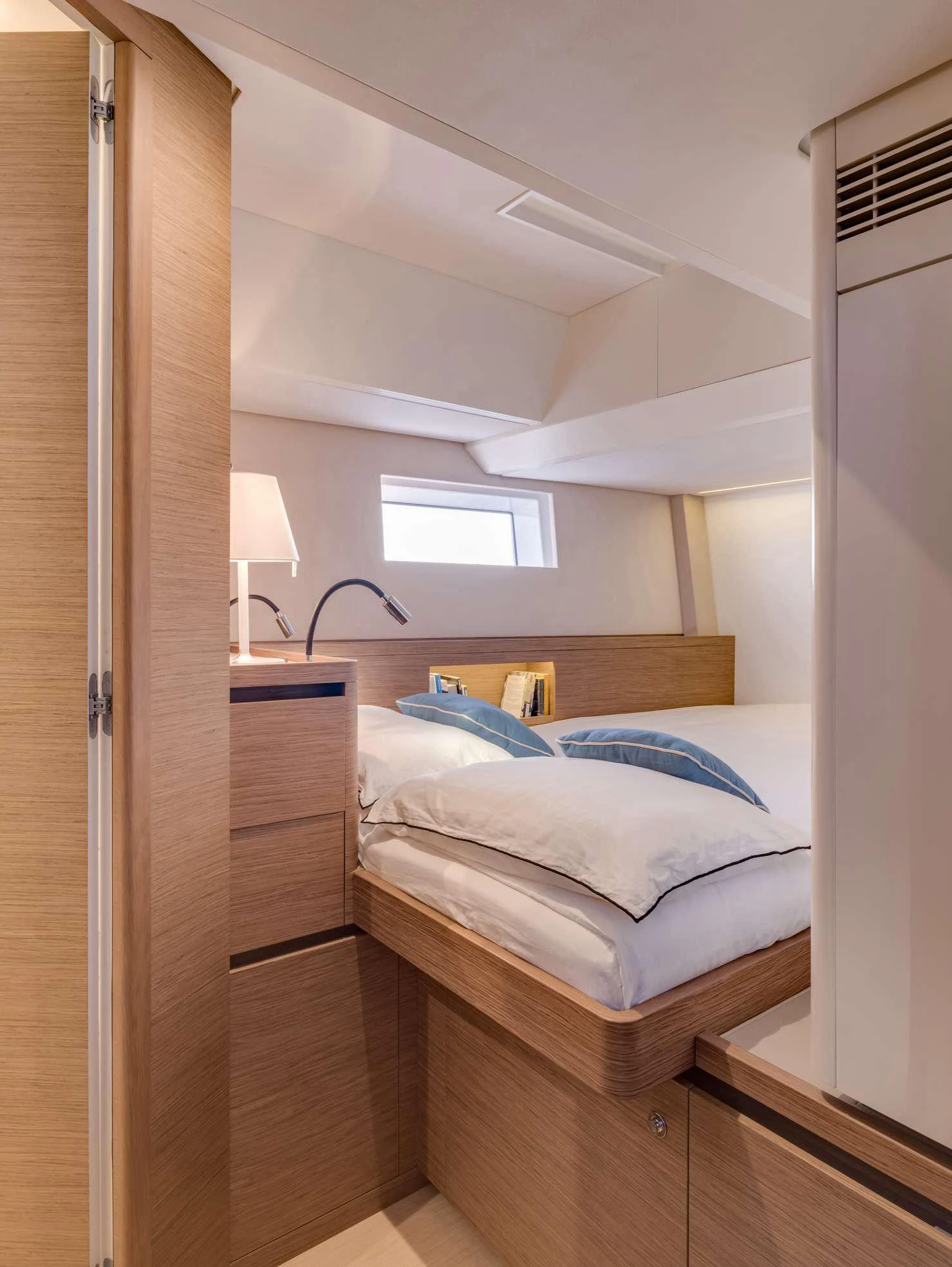 a bedroom with a bed and a lamp aboard MAHINA 3 Yacht for Charter
