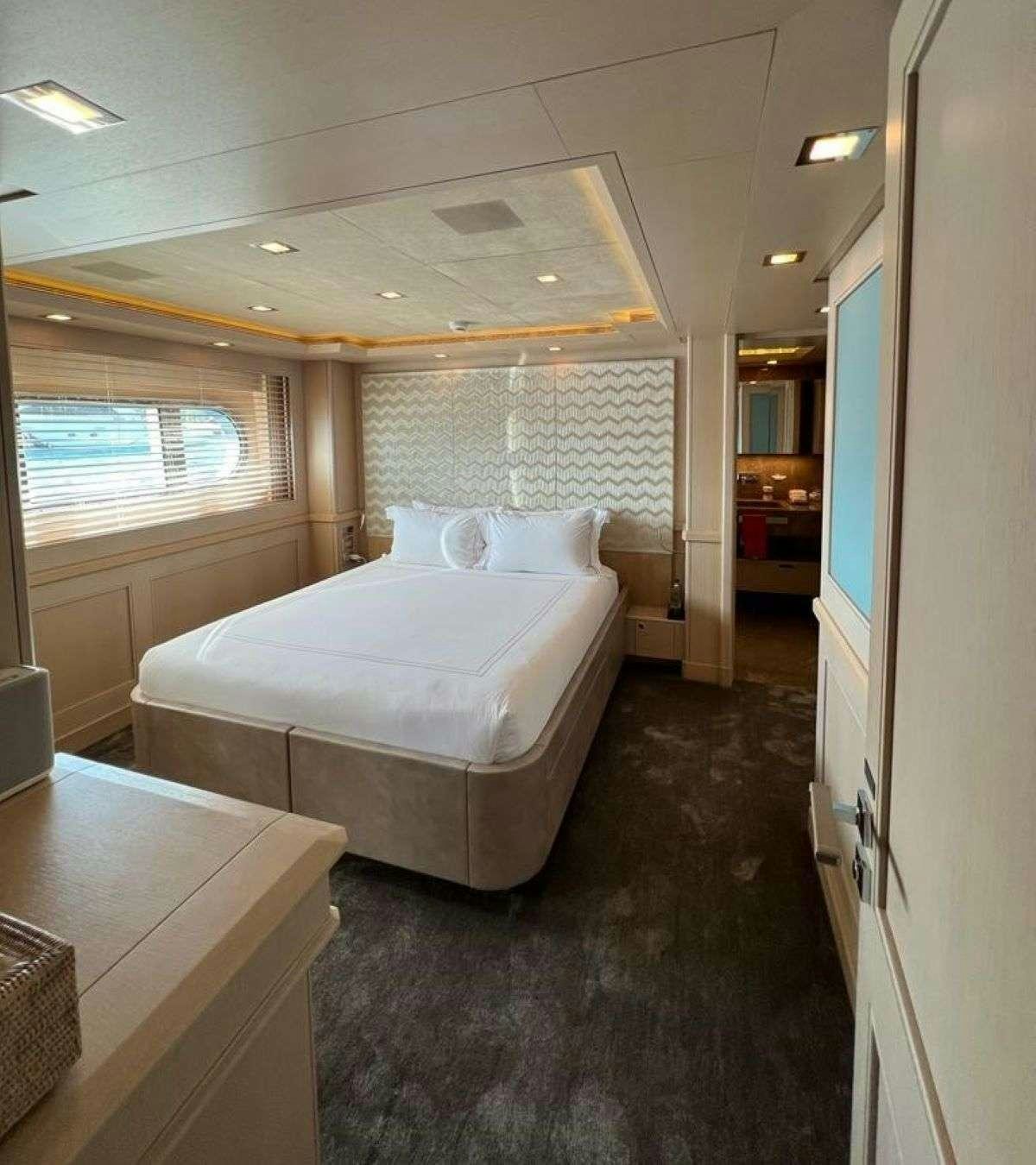 a bedroom with a bed and a table aboard POLARIS Yacht for Charter