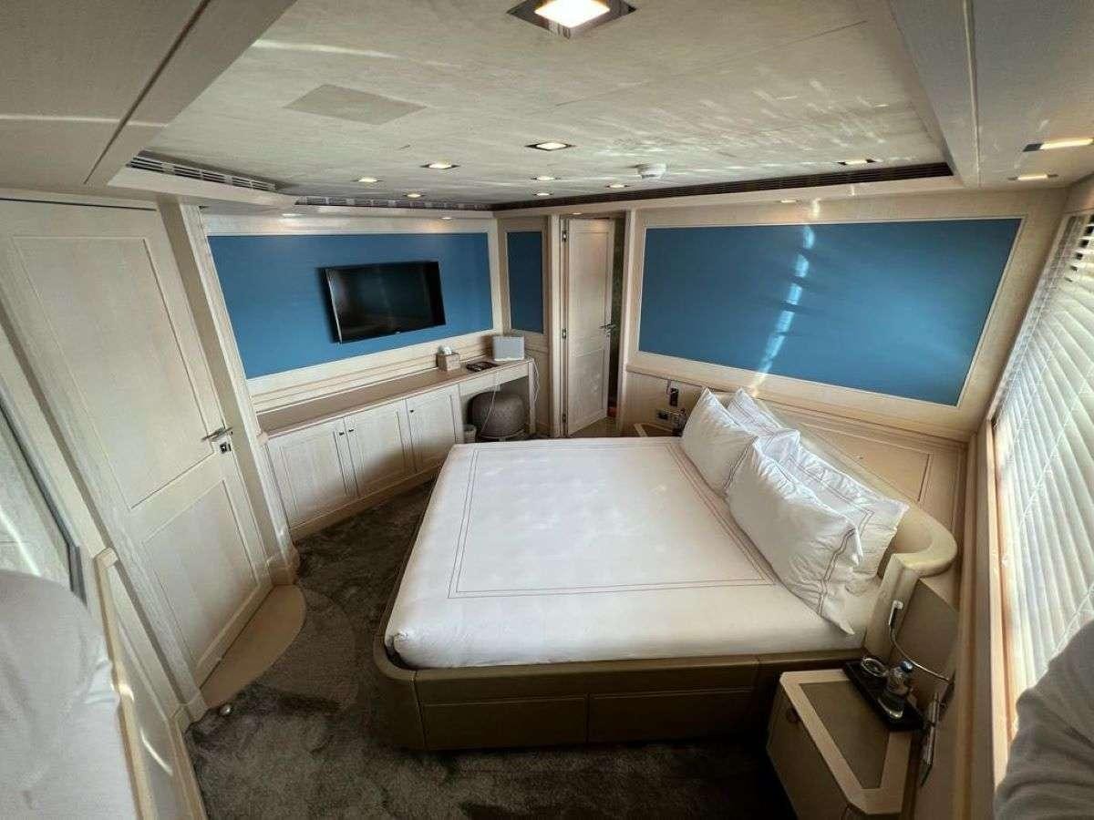 a room with a bed and a television aboard POLARIS Yacht for Charter