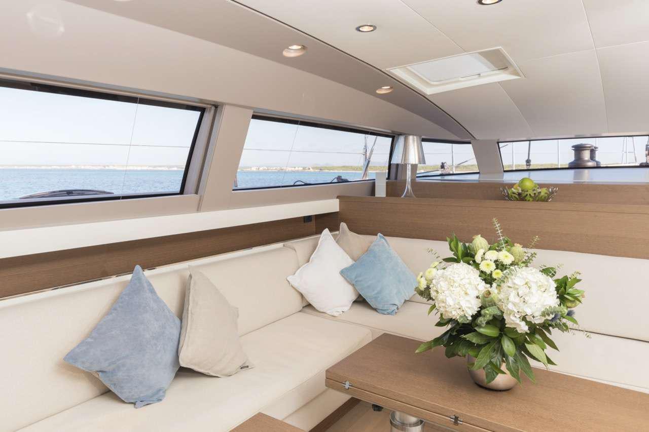 a room with a couch and a table with flowers aboard CNB 76 2017 Yacht for Charter