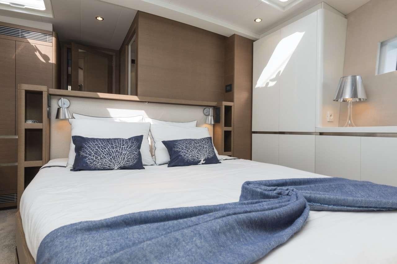 a bed with blue sheets aboard CNB 76 2017 Yacht for Charter