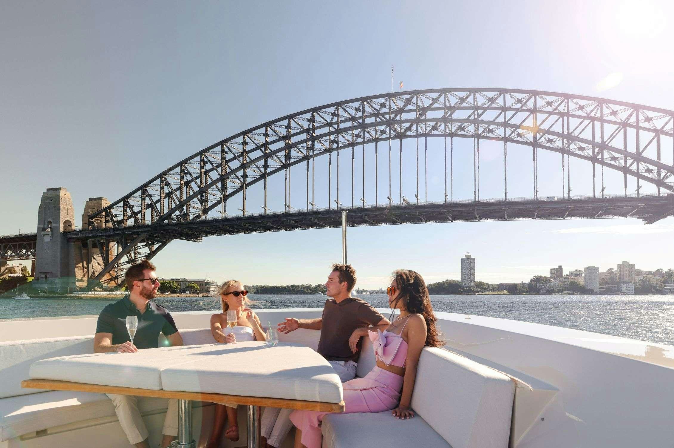 a group of people sitting at a table outside by a bridge aboard LANCE Yacht for Charter