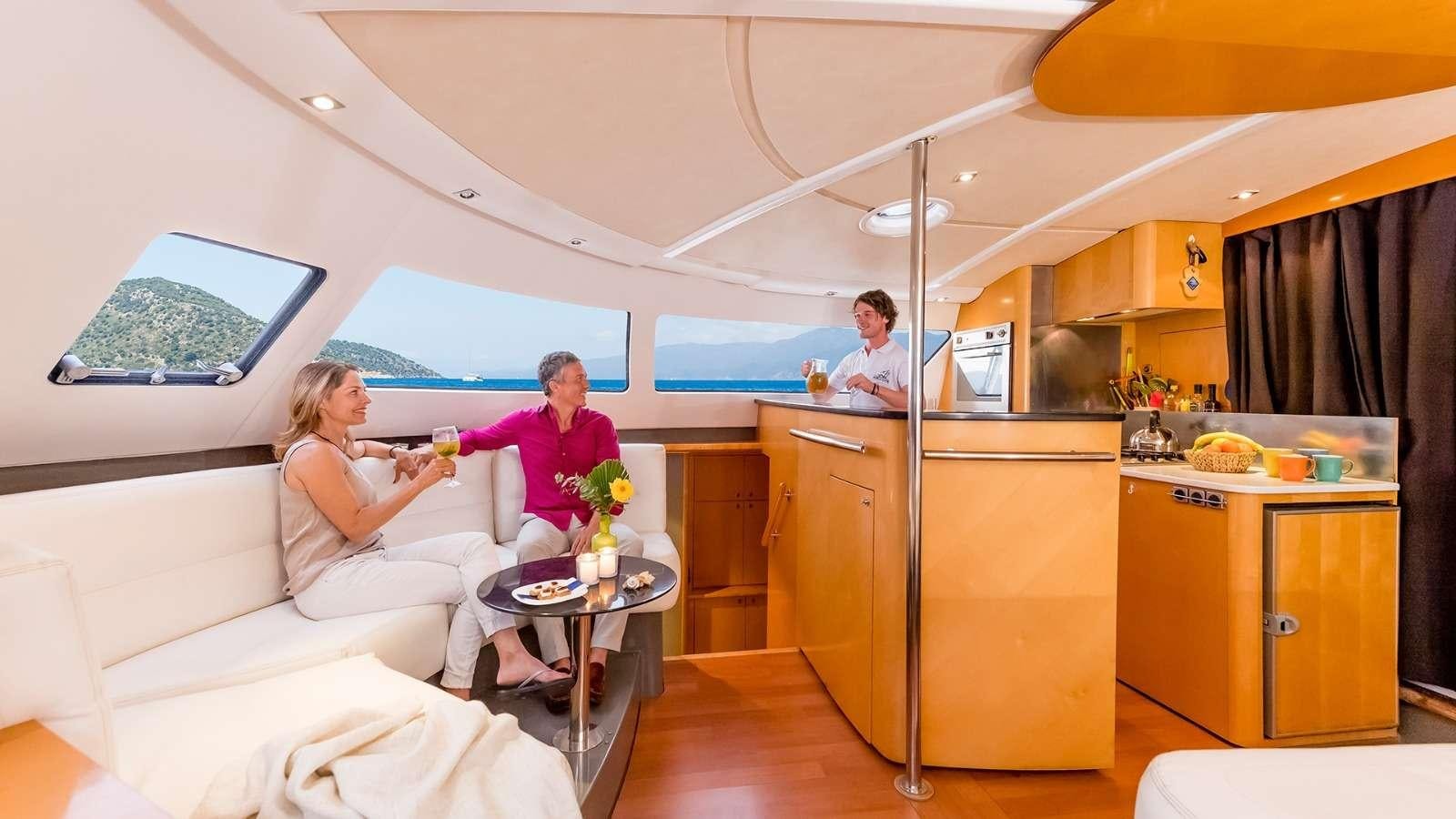 a man and a woman sitting in a living room aboard ZORBA CAT Yacht for Charter