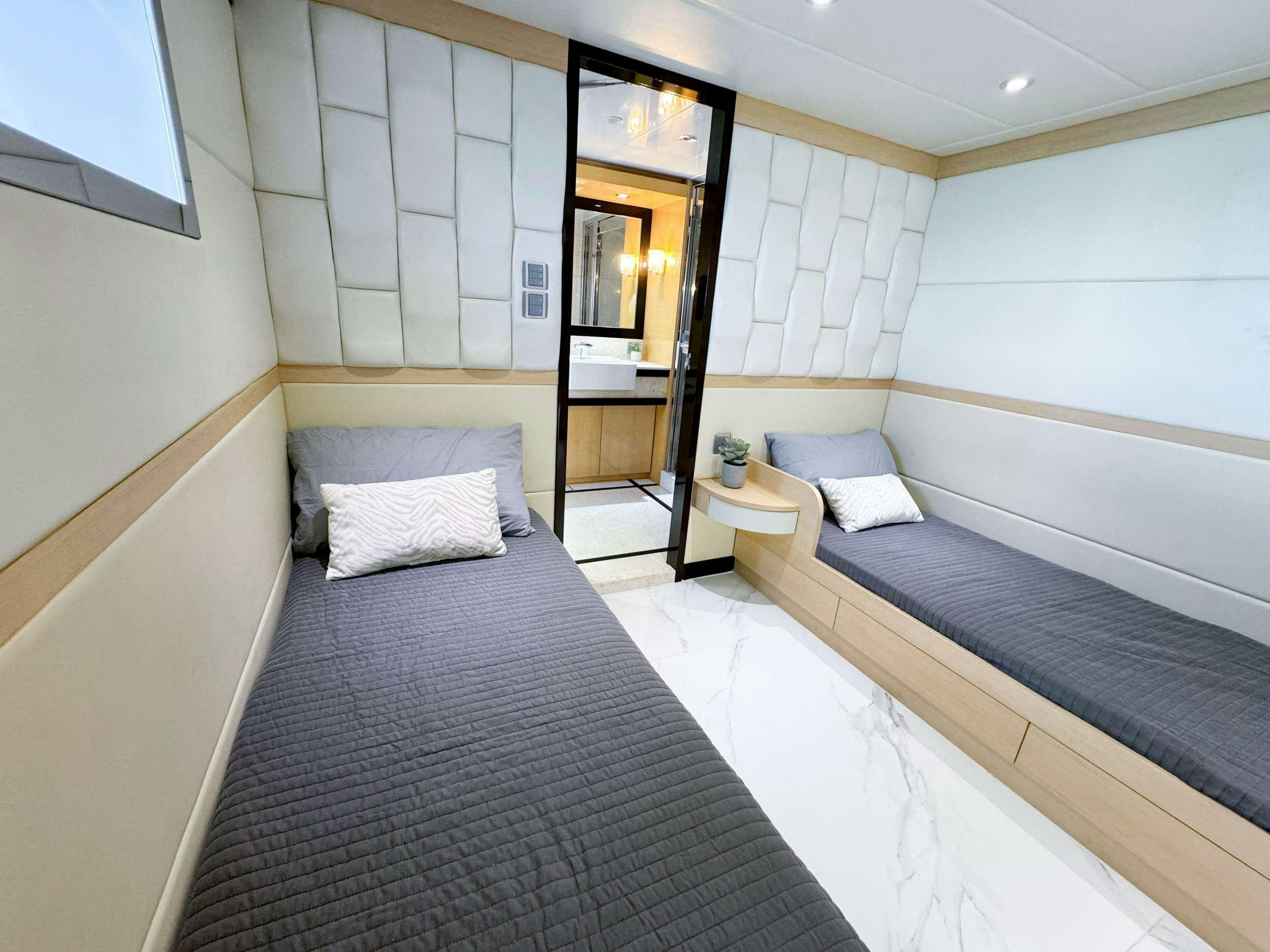 a room with two beds aboard PRIVILEGE Yacht for Charter
