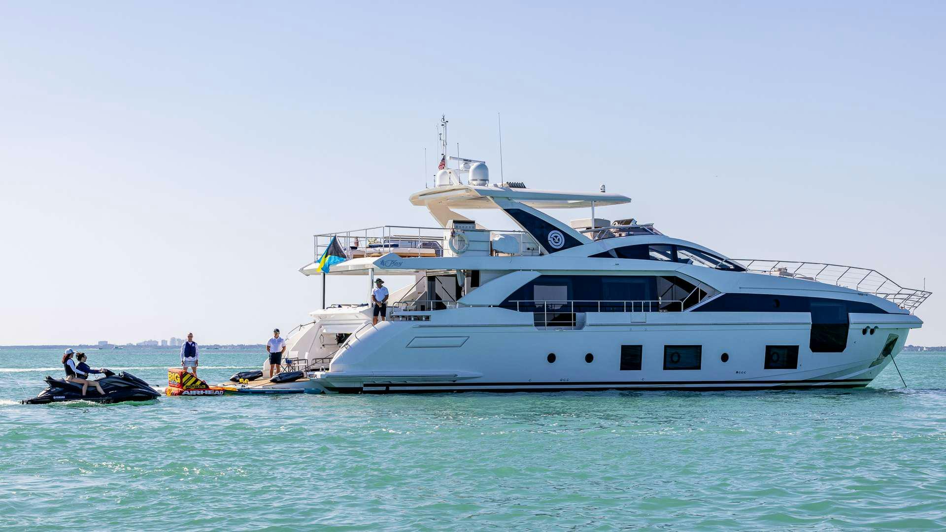 a large white boat with a couple of people on it aboard 4 PLAY Yacht for Charter