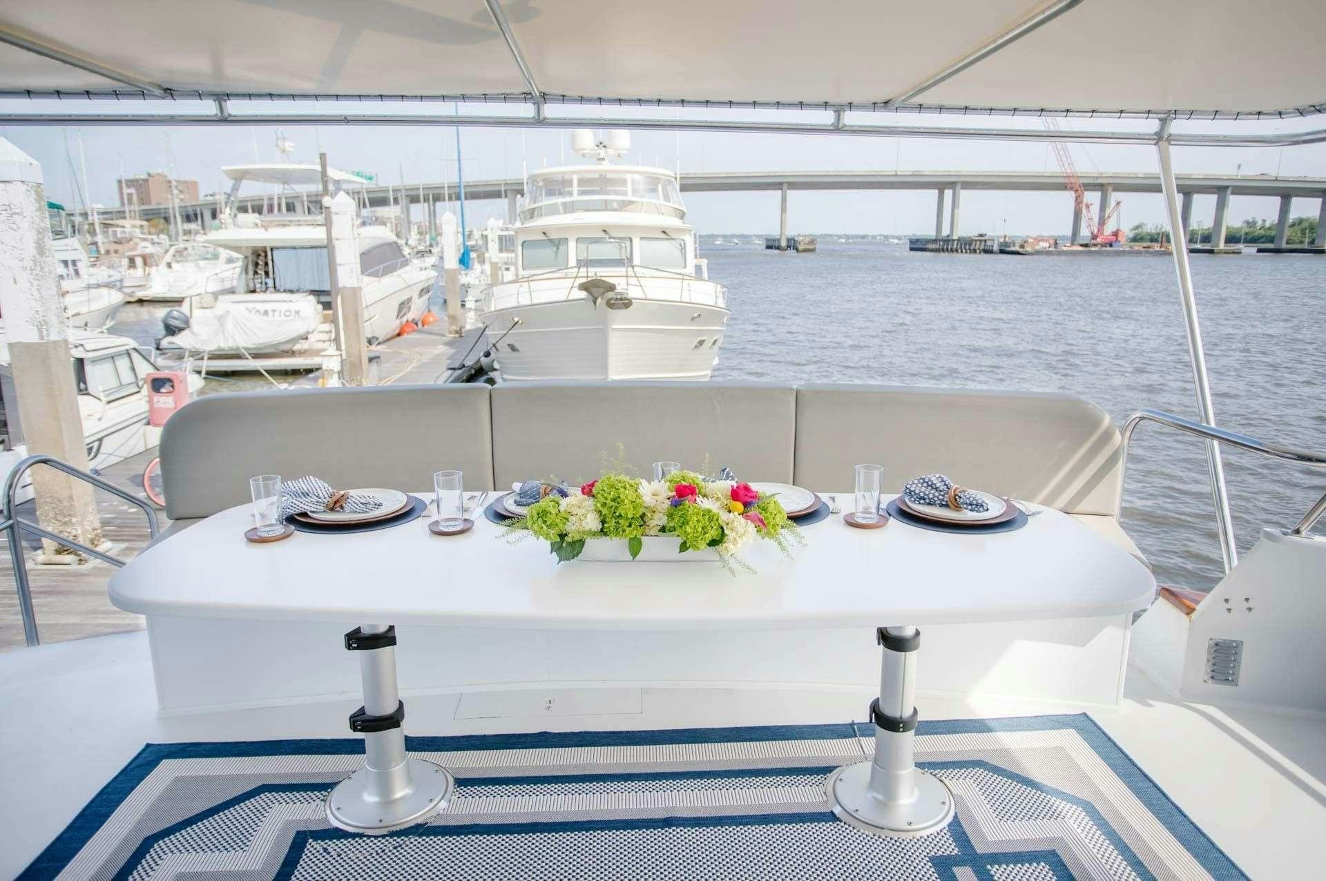 a table with plates and flowers on it aboard MISS EMILY Yacht for Charter