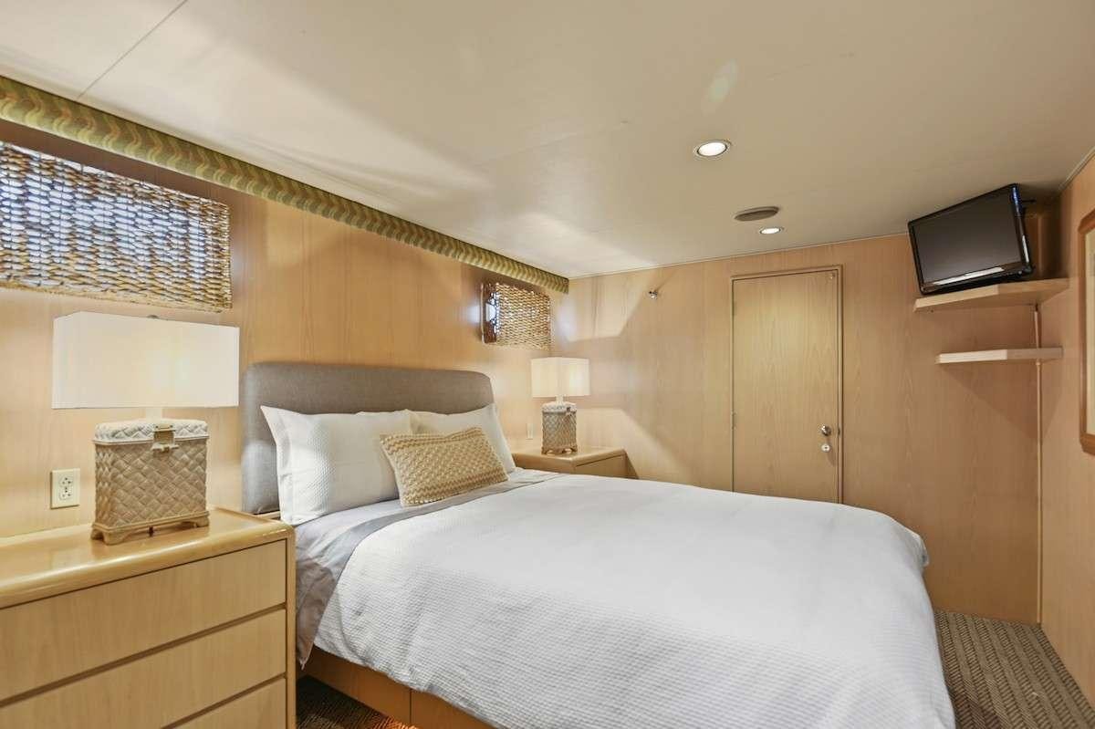 a bedroom with a bed and a television aboard MISS EMILY Yacht for Charter