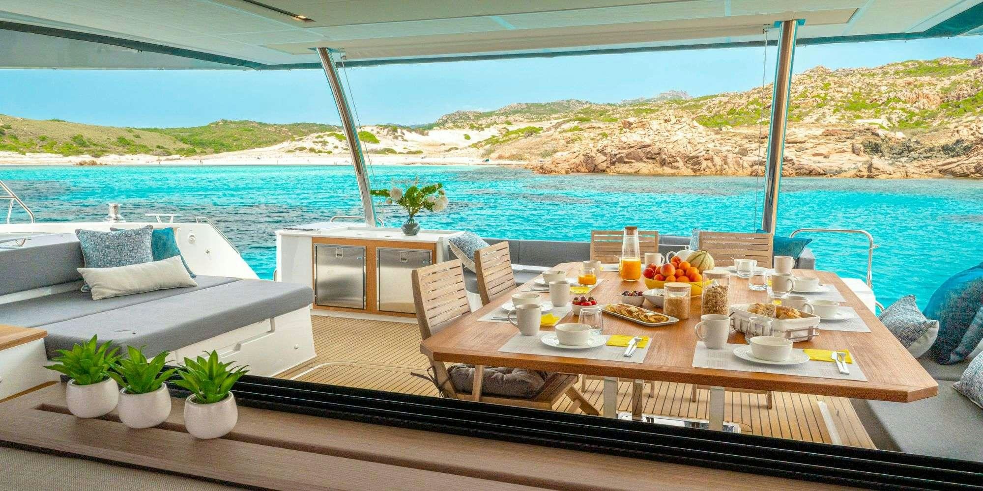 a table with chairs and a view of the ocean aboard SEMPER FIDELIS Yacht for Charter
