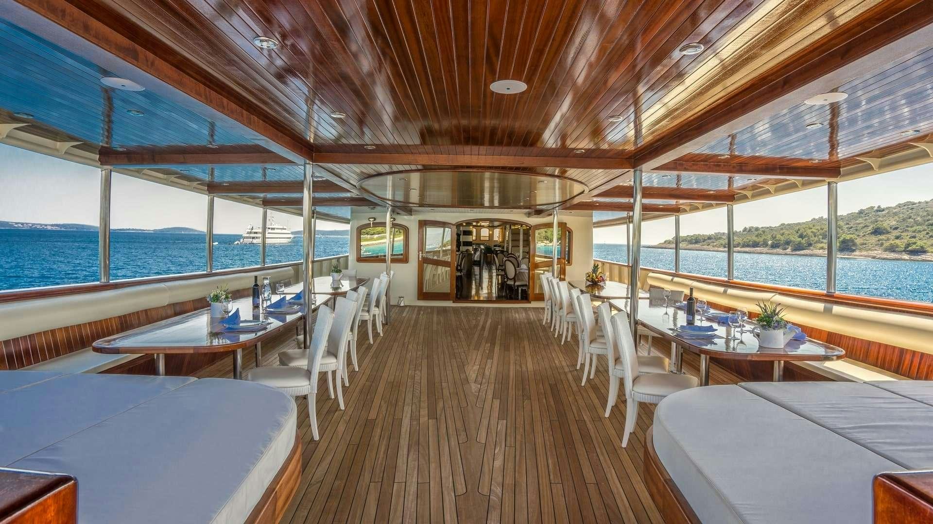 a room with tables and chairs aboard CASABLANCA Yacht for Charter