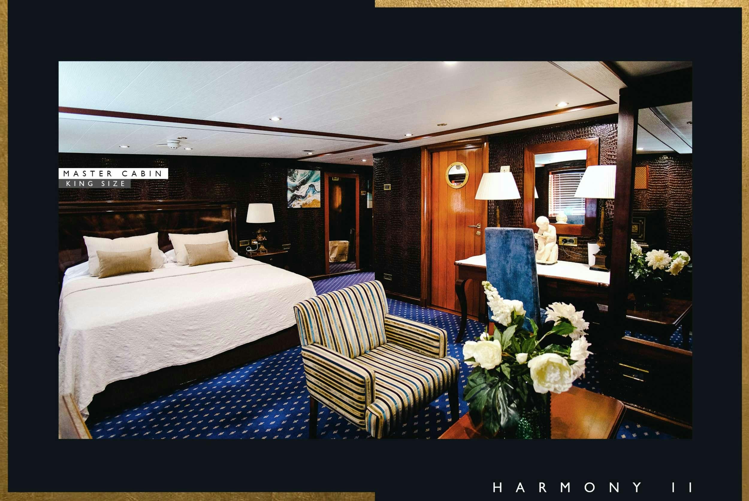 a bed with a white bed and a blue and white striped bed spread aboard HARMONY II Yacht for Charter