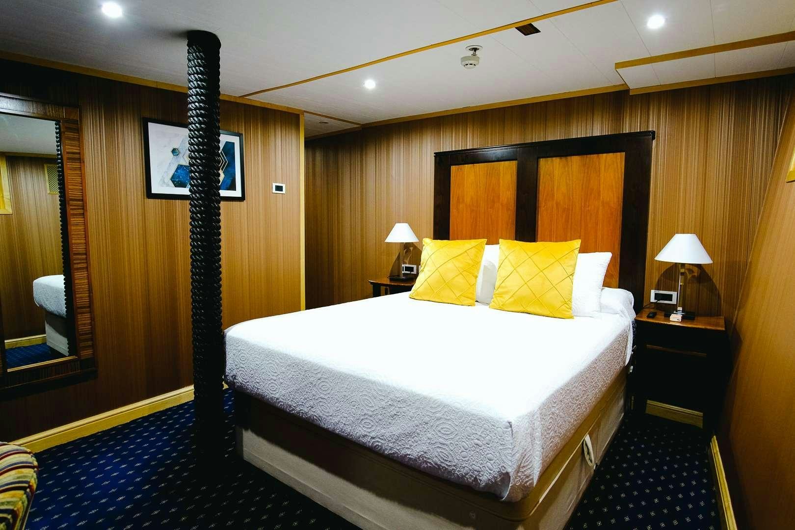 a bed with a black headboard aboard HARMONY II Yacht for Charter
