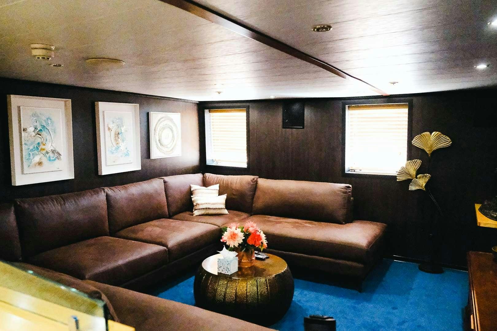 a living room with a couch and a table aboard HARMONY II Yacht for Charter