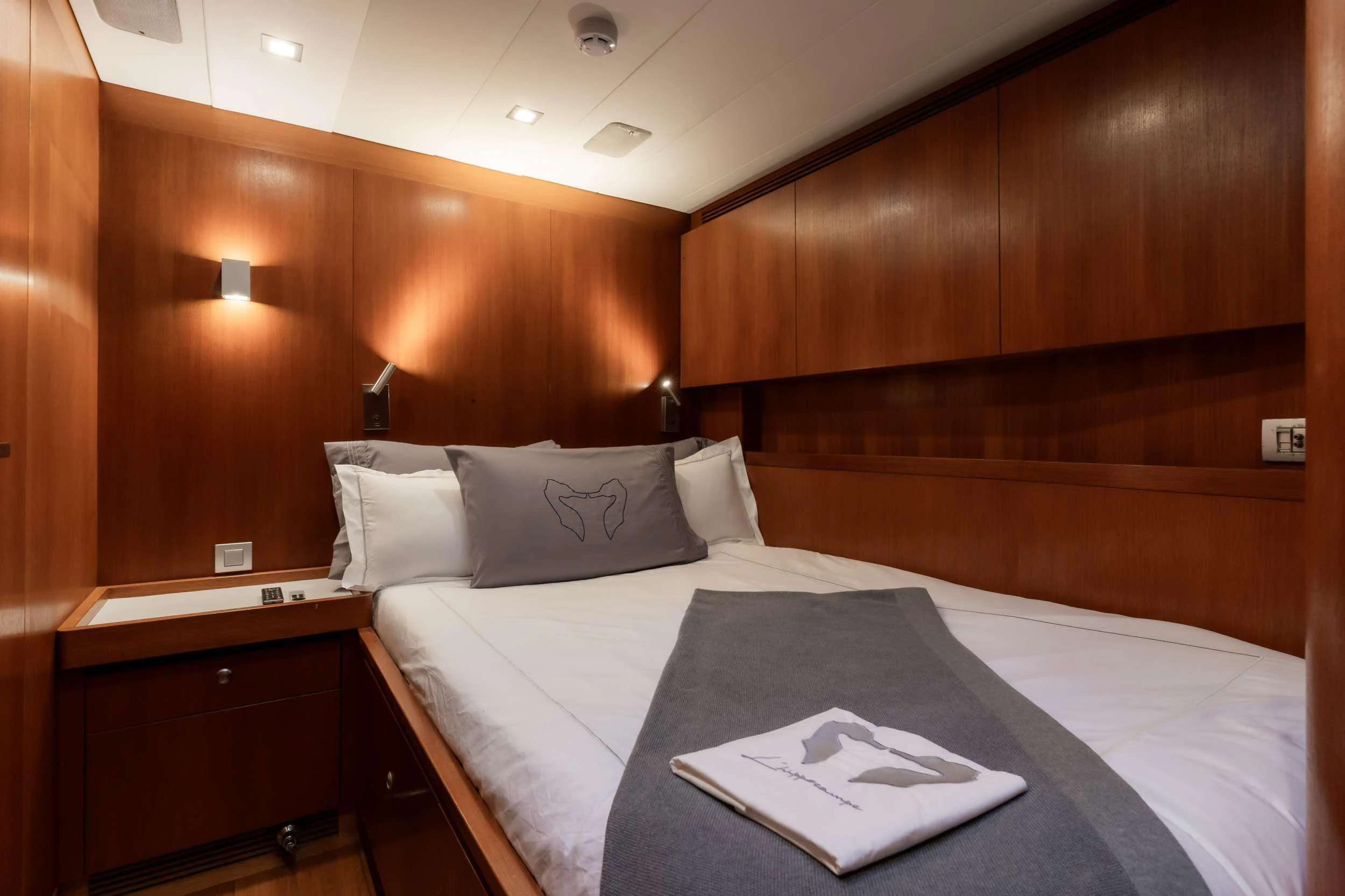 a bed with white sheets aboard VARSOVIE Yacht for Charter