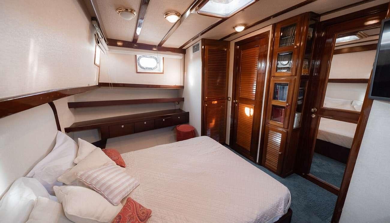 a room with a bed and a television aboard SEATZEN Yacht for Charter