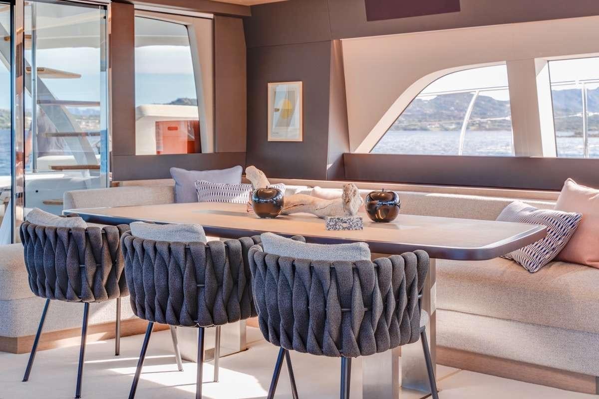 a dining table with a view of the ocean aboard SEVENTY8 Yacht for Charter