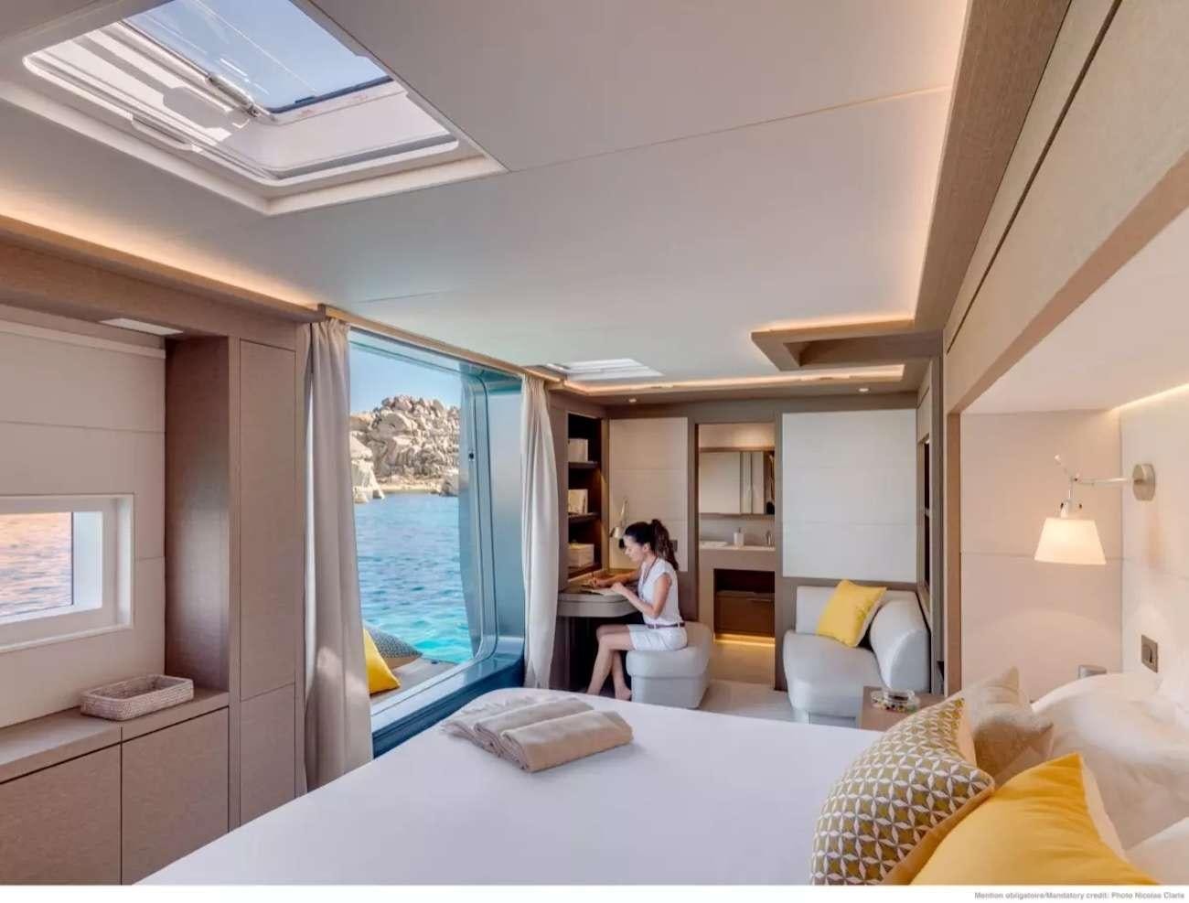 a person sitting at a table in a bedroom aboard SEVENTY8 Yacht for Charter