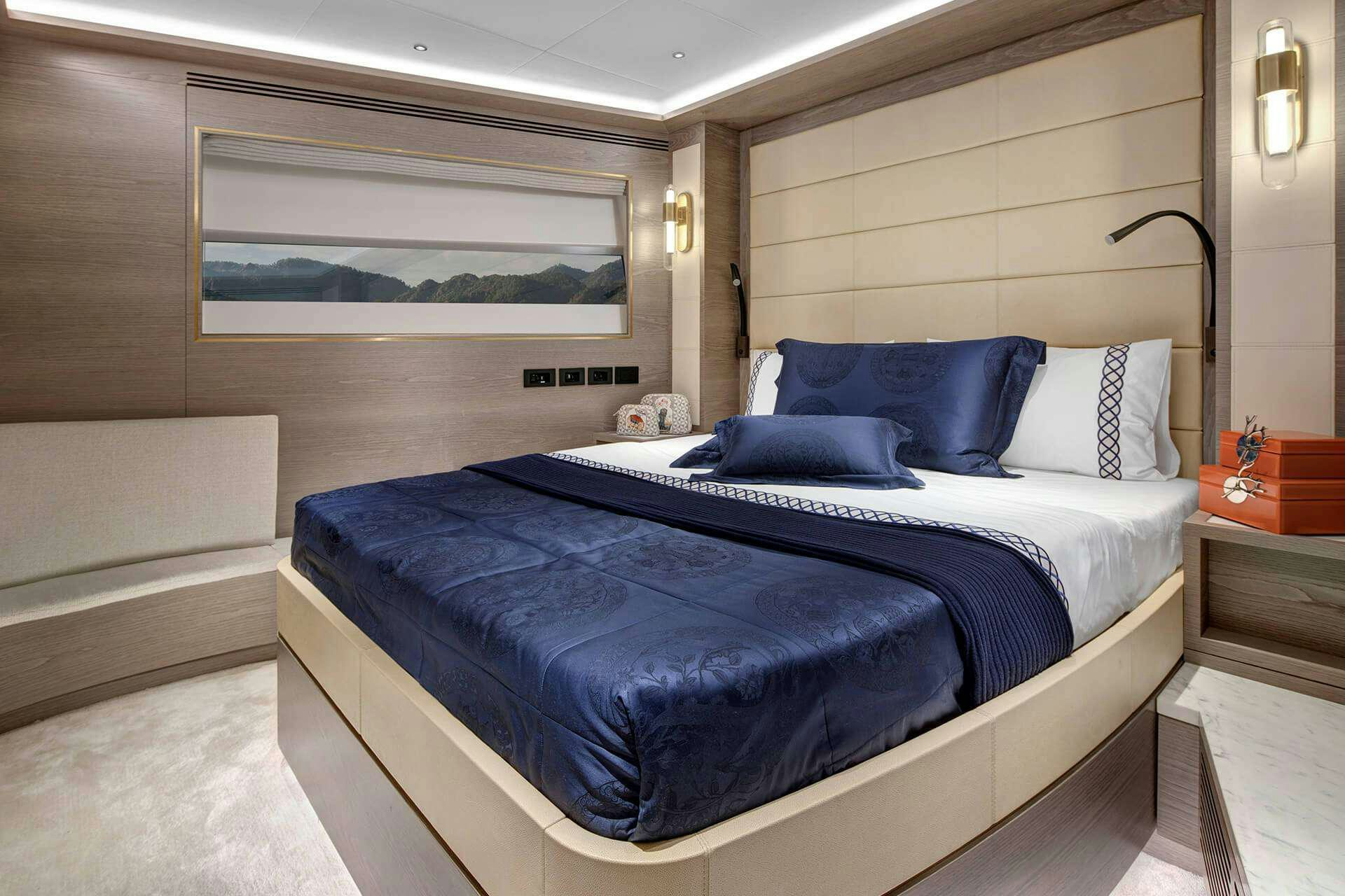a bed with a blue comforter aboard SAINT Yacht for Charter