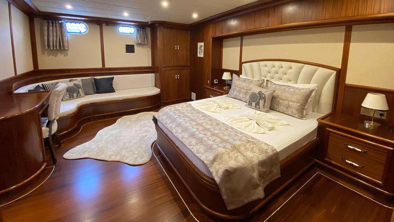 a room with a bed and a chair aboard LA MIA STELLA Yacht for Charter