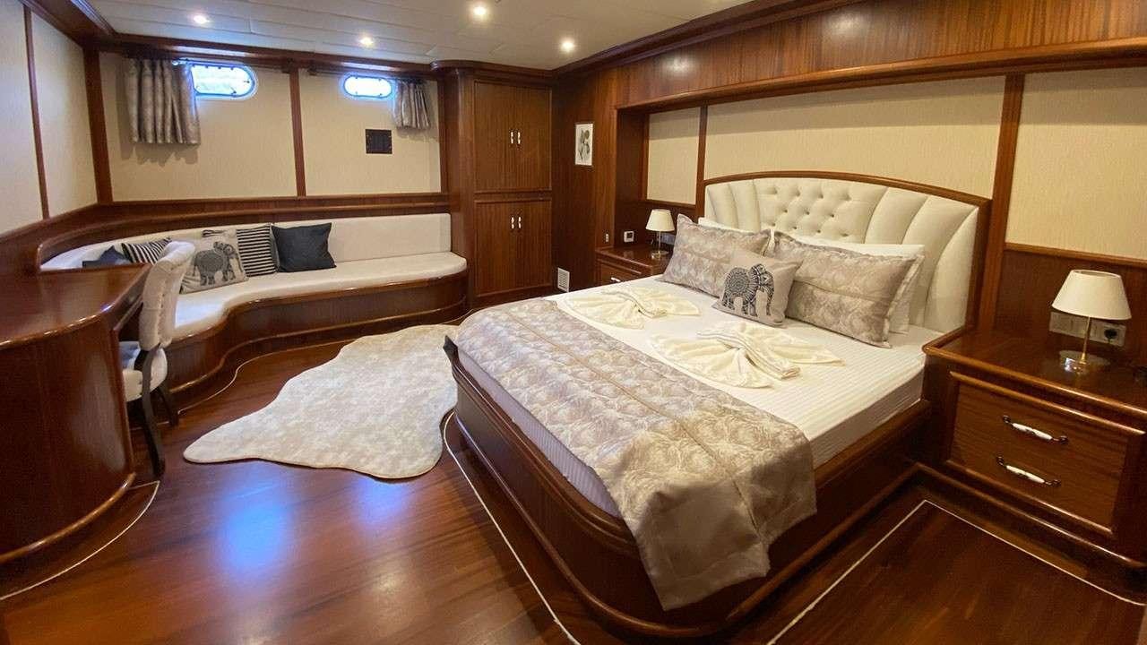 a room with a bed and a chair aboard LA MIA STELLA Yacht for Charter