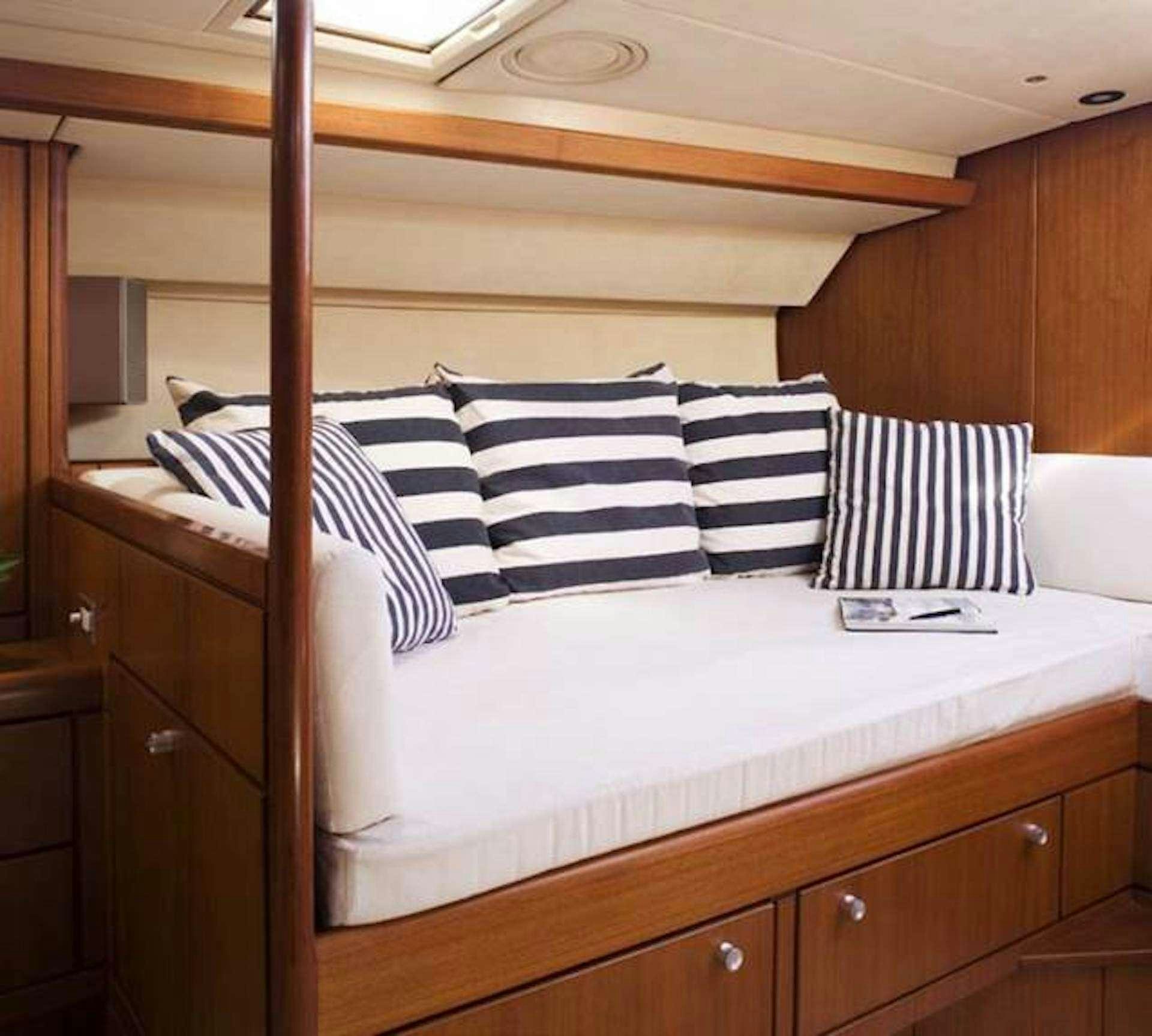 a bed with white and black striped pillows aboard ABEON Yacht for Charter