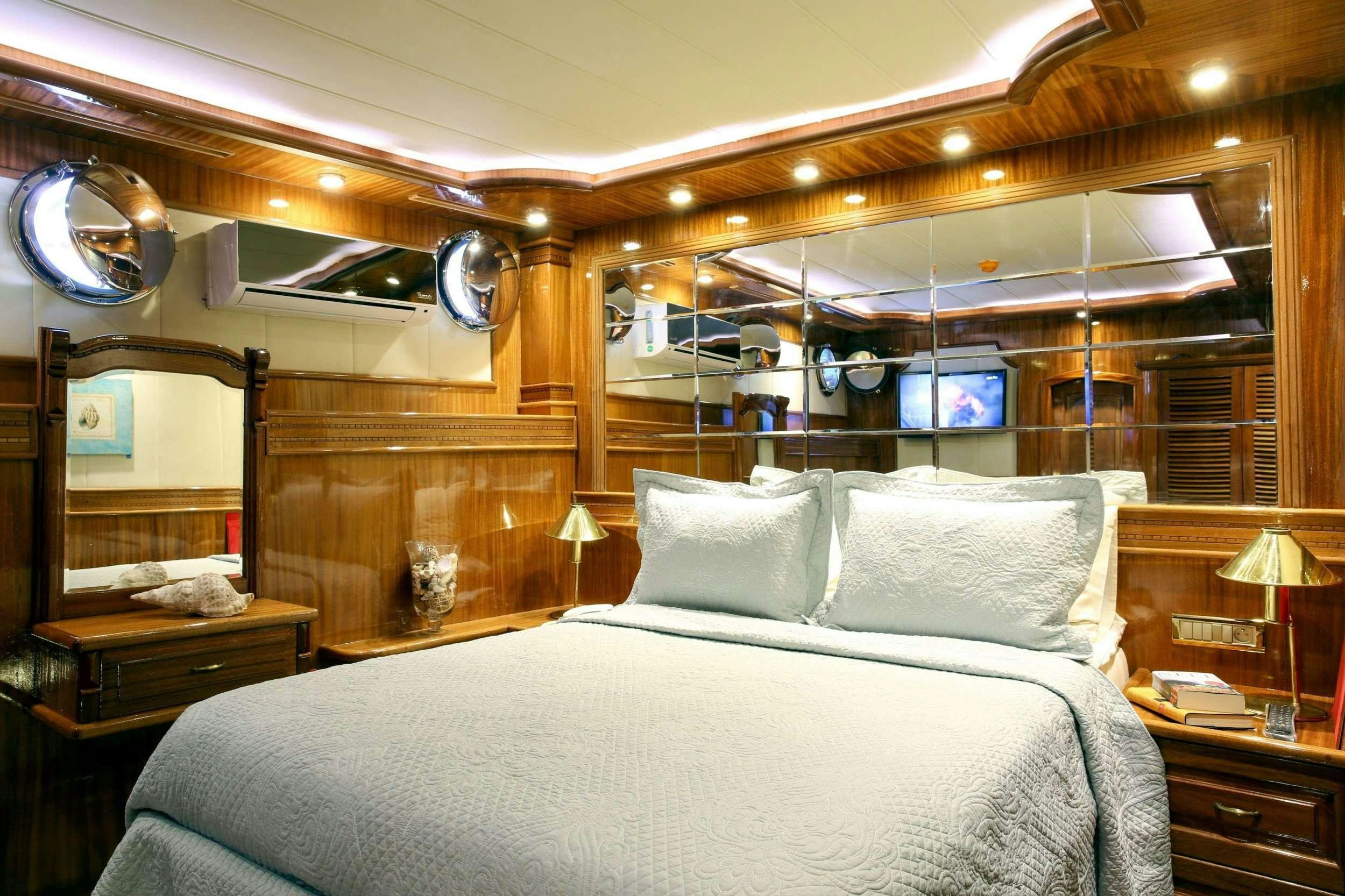 a bed with a white bed spread aboard QUEEN ATLANTIS Yacht for Charter