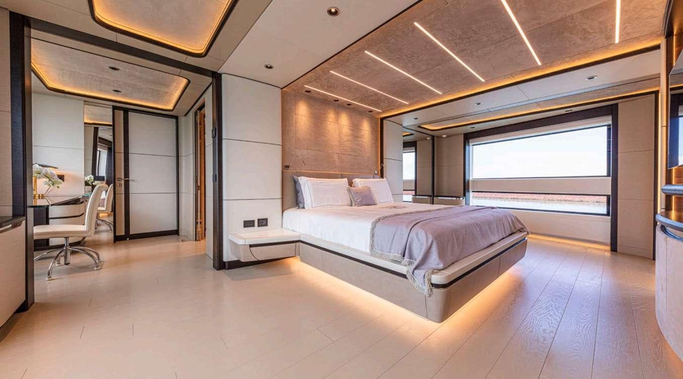 a room with a bed and a large window aboard VAYUS Yacht for Charter