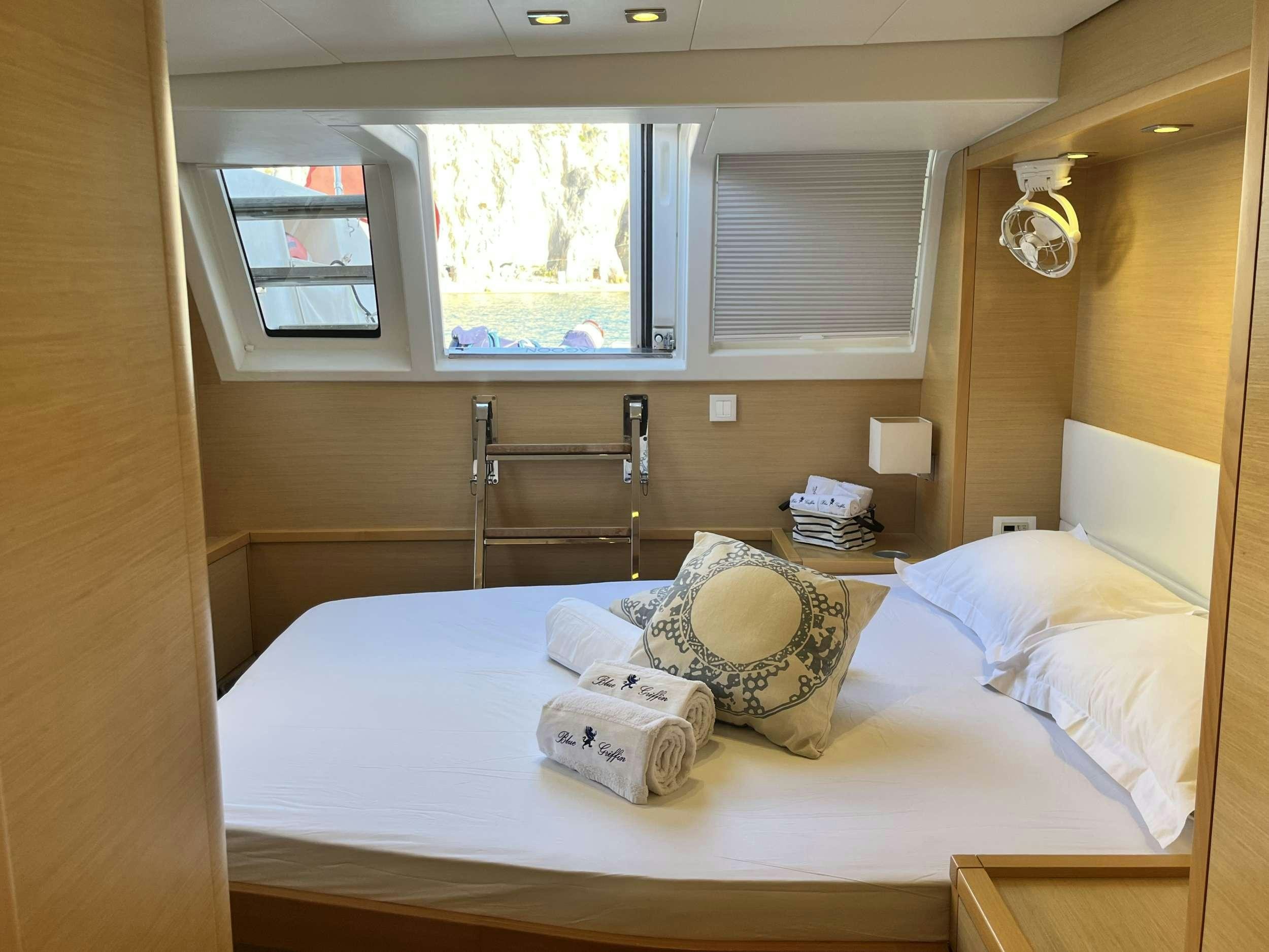 a bed with a pillow and a lamp on it aboard BLUE GRIFFIN - SUMMER Yacht for Charter