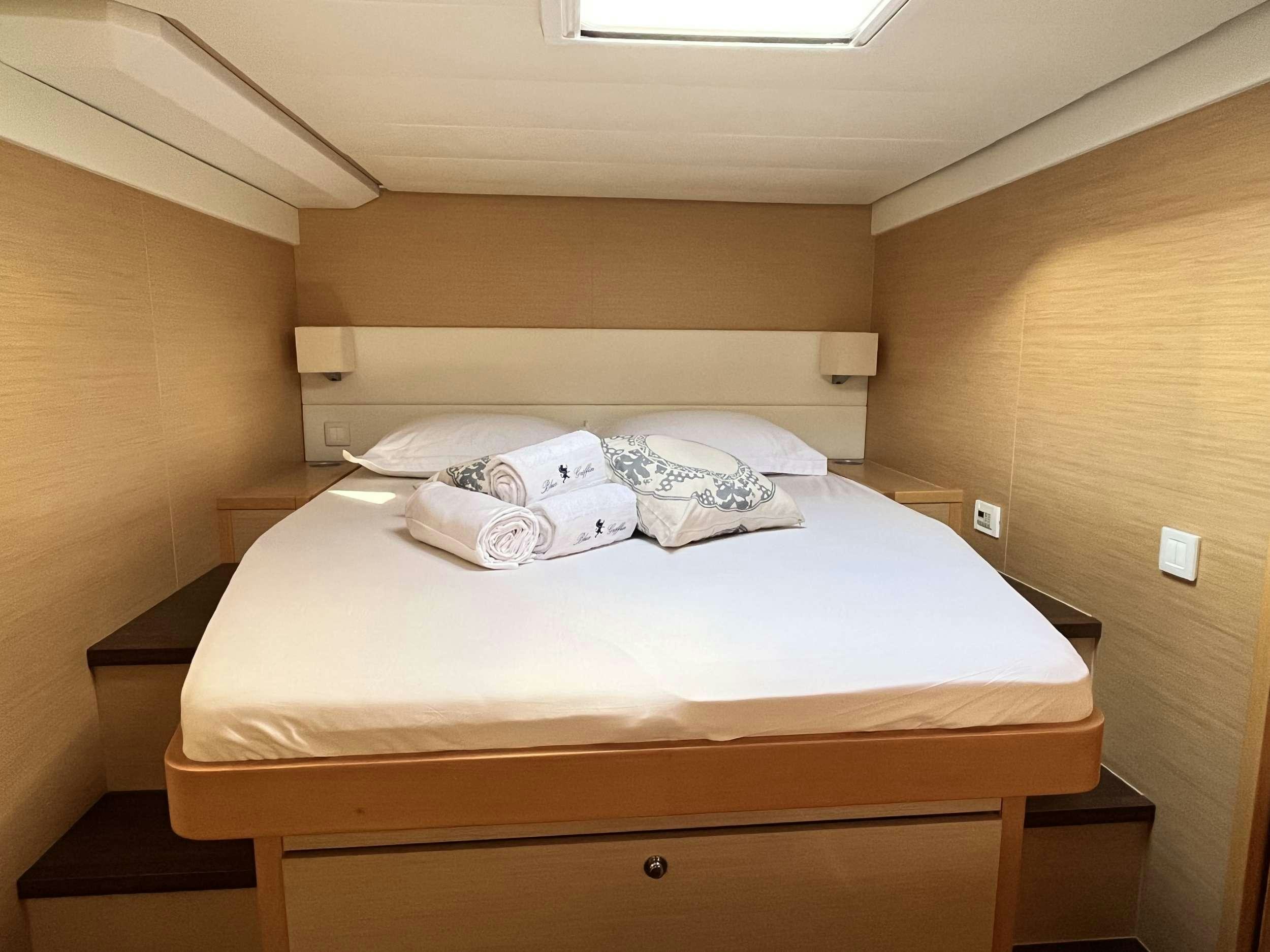 a bed with white sheets aboard BLUE GRIFFIN - SUMMER Yacht for Charter