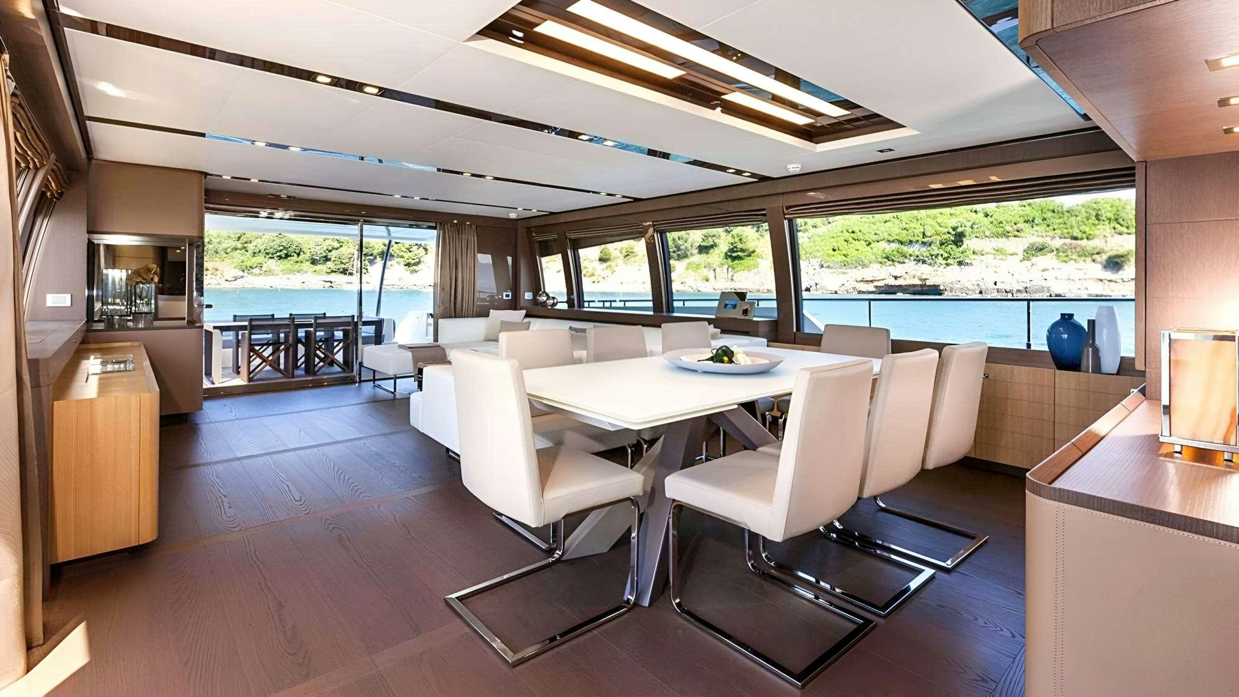 a room with a table chairs and a large window aboard IVA Yacht for Charter